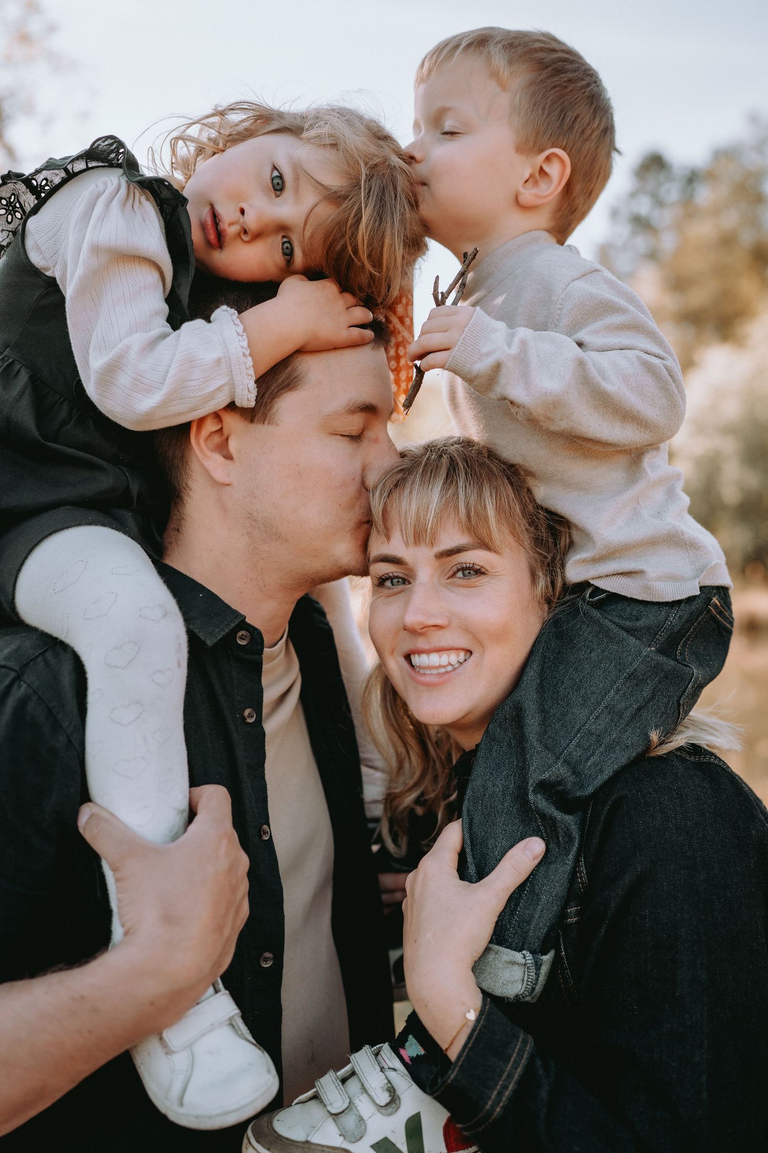 Kinder umarmen und küssen ihre Eltern beim Familien-Shooting. Lebendige und lockere Familienfotos im Kanton Solothurn.
