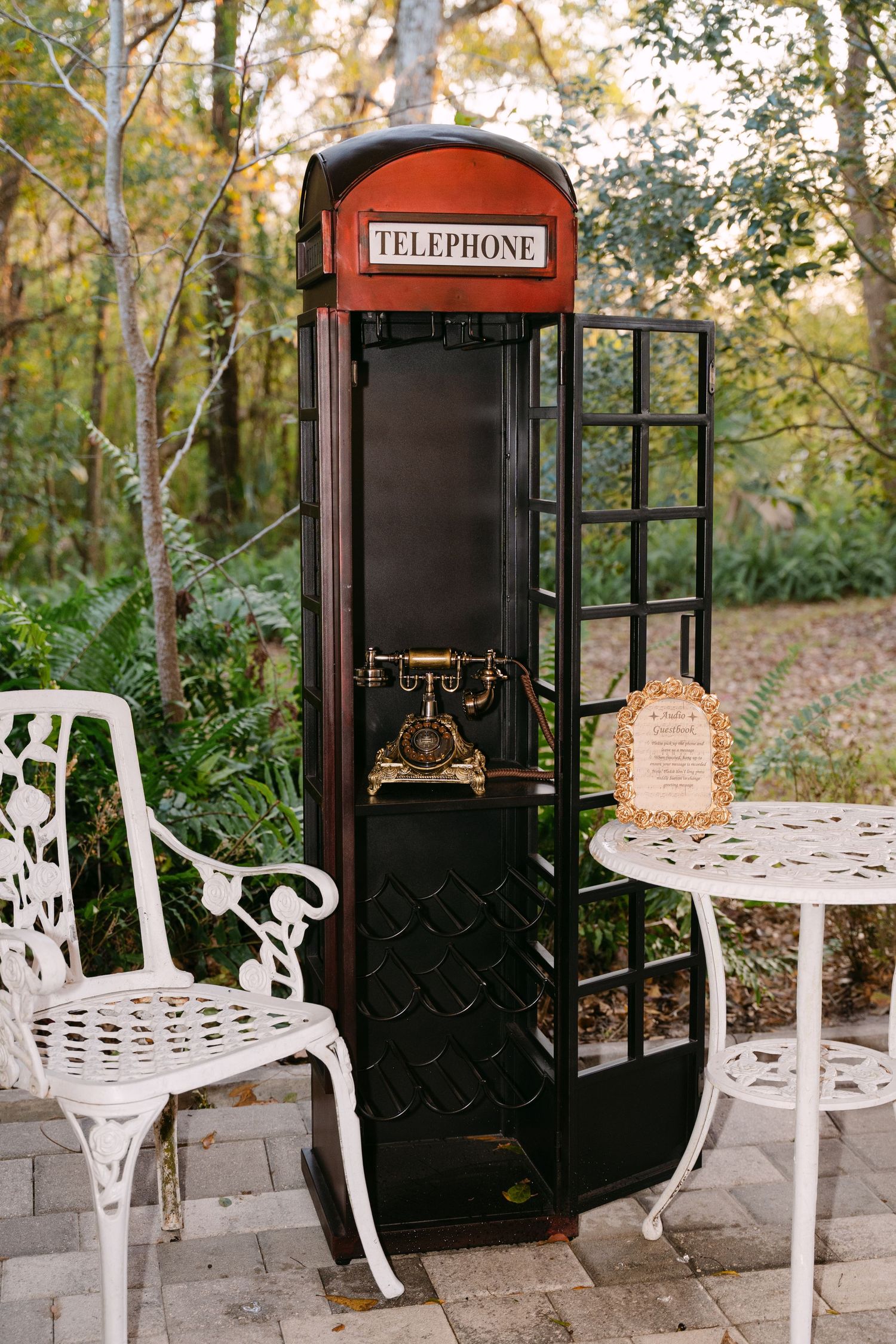 Vintage red British telephone booth with antique gold phone used as wedding guest book station.
