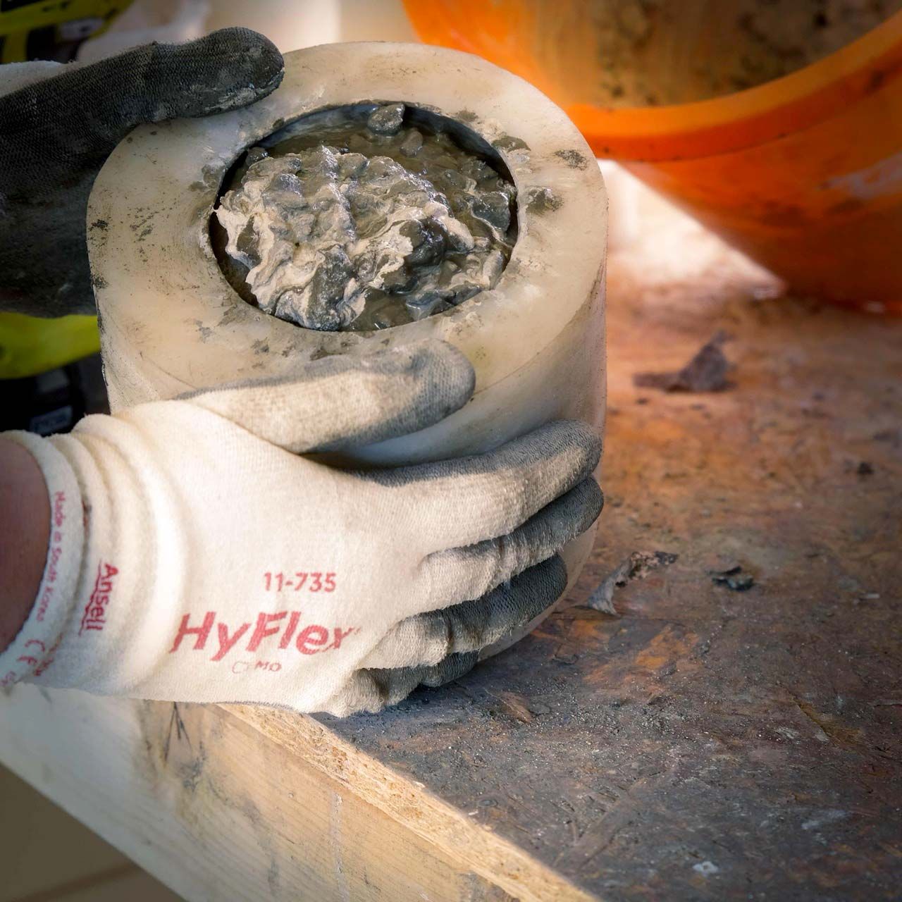 Hands moulding a handcrafted concrete plant pot in an artisan workshop in the Scottish Highlands.