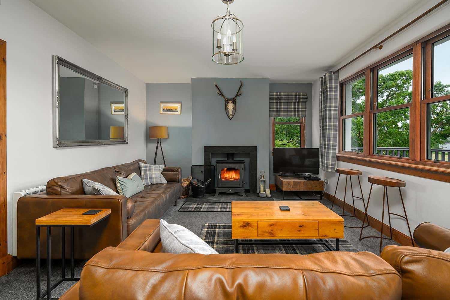 Cosy living room in a Scottish Highland holiday cottage with wood-burning stove, coffee table and comfortable seating.