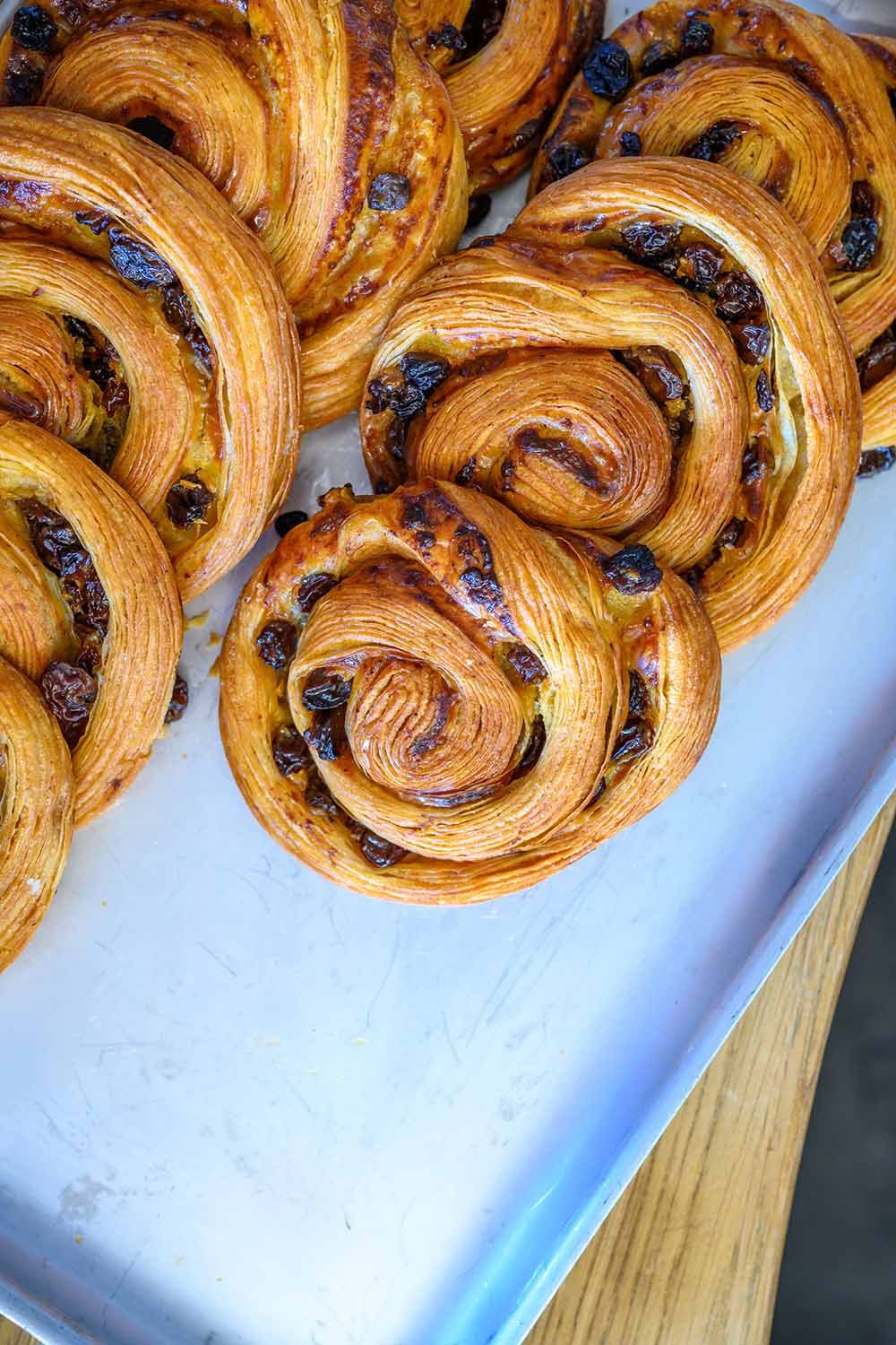 Close-up shot of freshly baked cinnamon swirls and pastries displayed on a baking tray.