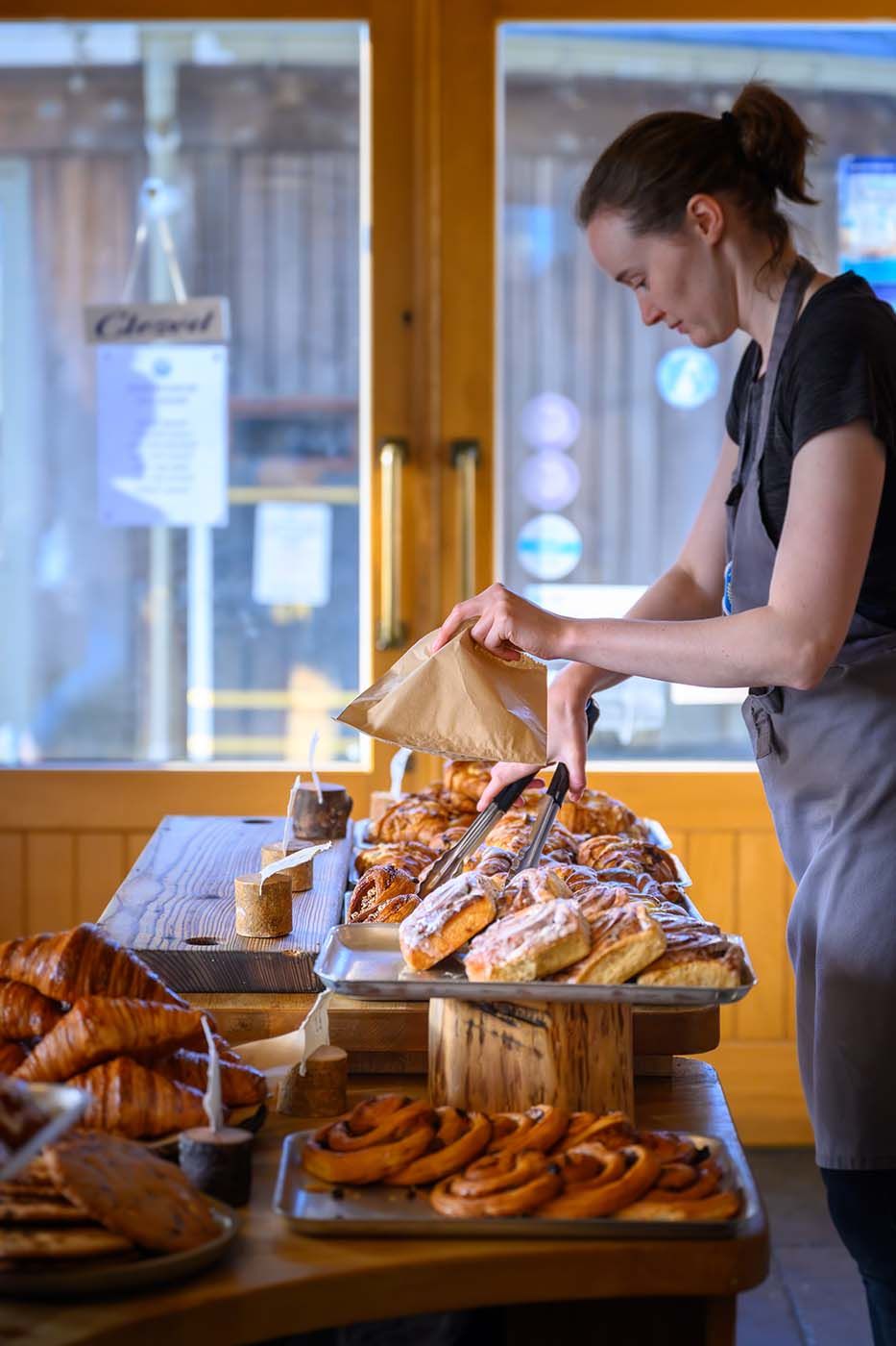 Bakery staff arranging a display of fresh baked goods at The Bakehouse in Mallaig