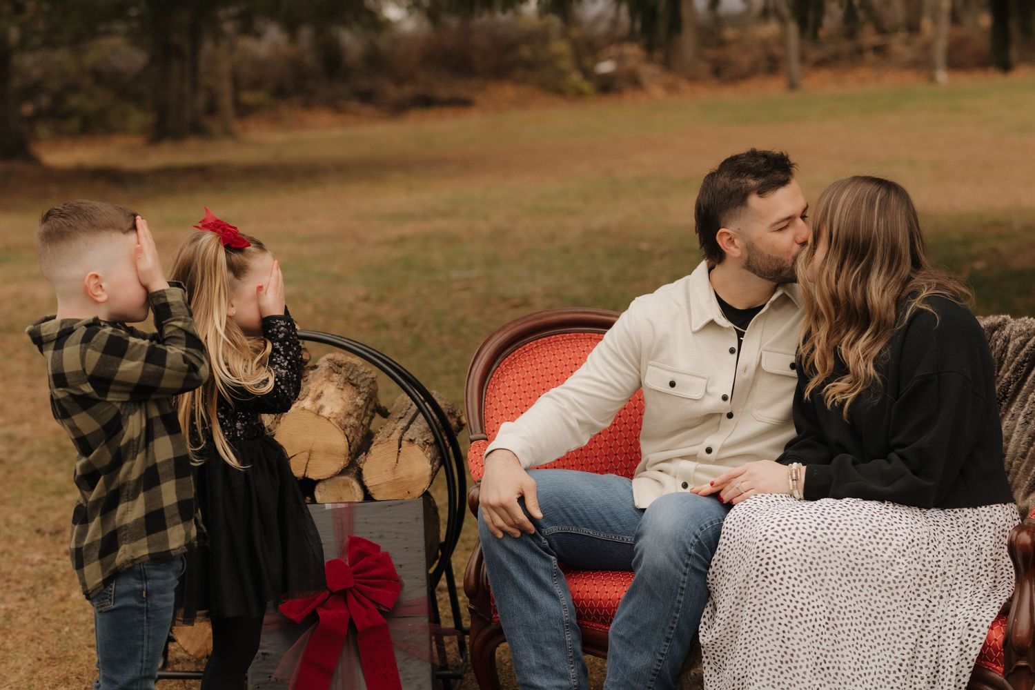 Casual outdoor family photo session with a vintage red couch as prop.