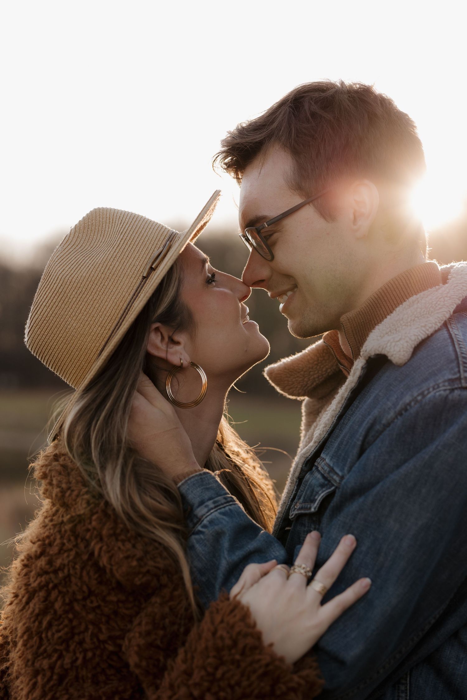 Intimate close-up of a couple sharing a tender moment in warm sunset lighting.