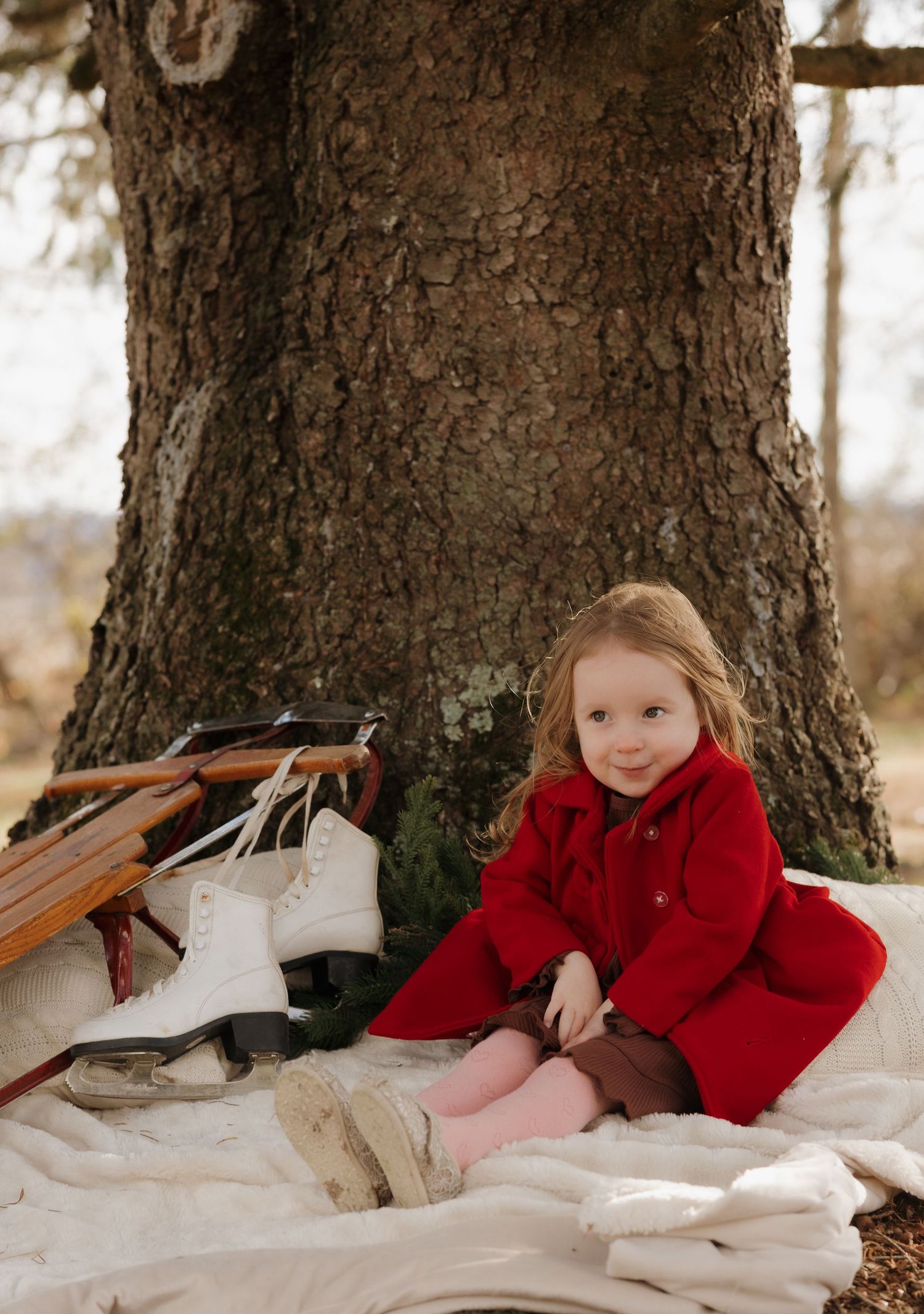 Winter outdoor portrait session against large tree trunk.