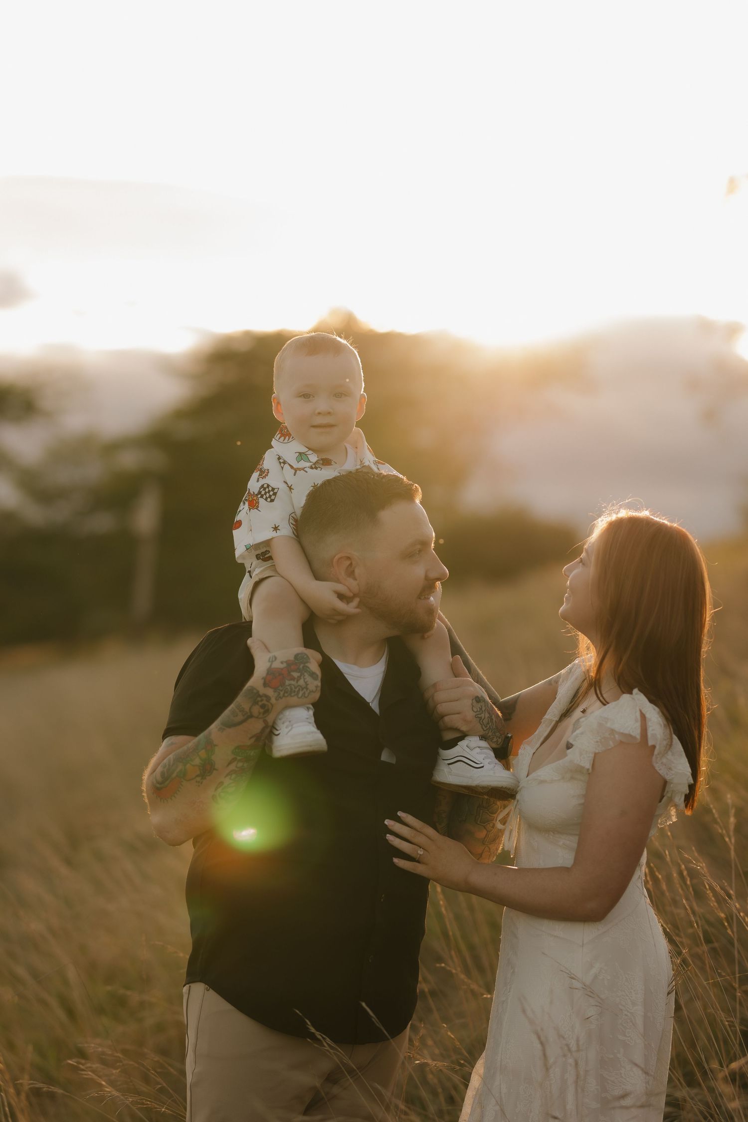 Family shares joyful moments together in a sunlit field at golden hour.
