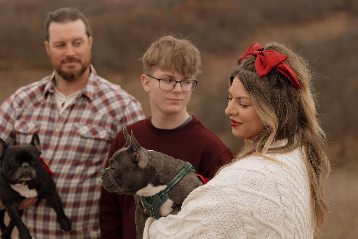 Family and dog posing together in a rustic outdoor setting during golden hour.