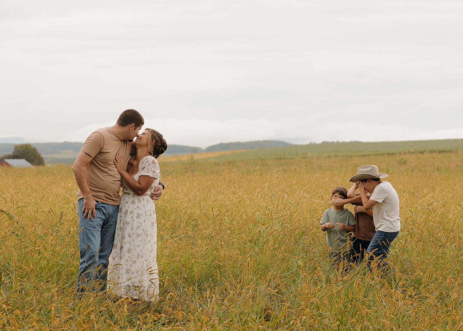 Silhouettes of a family sharing intimate moments in a golden wheat field.