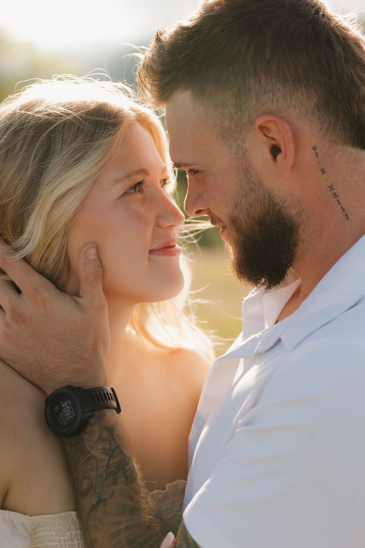 Close-up romantic sequence of a couple embracing in golden sunlight with visible tattoos and intimate expressions.