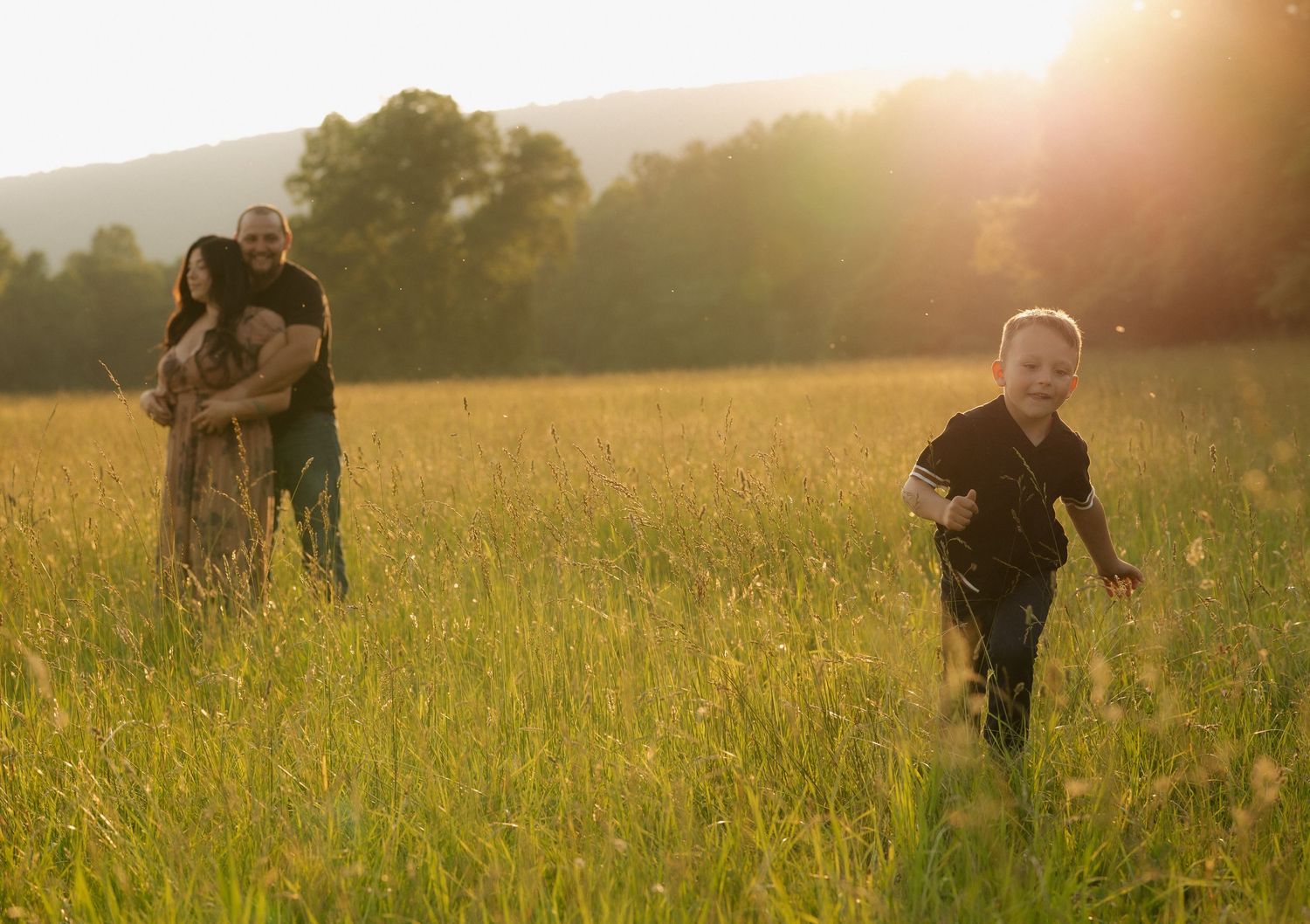 People running through tall grass field during sunset.