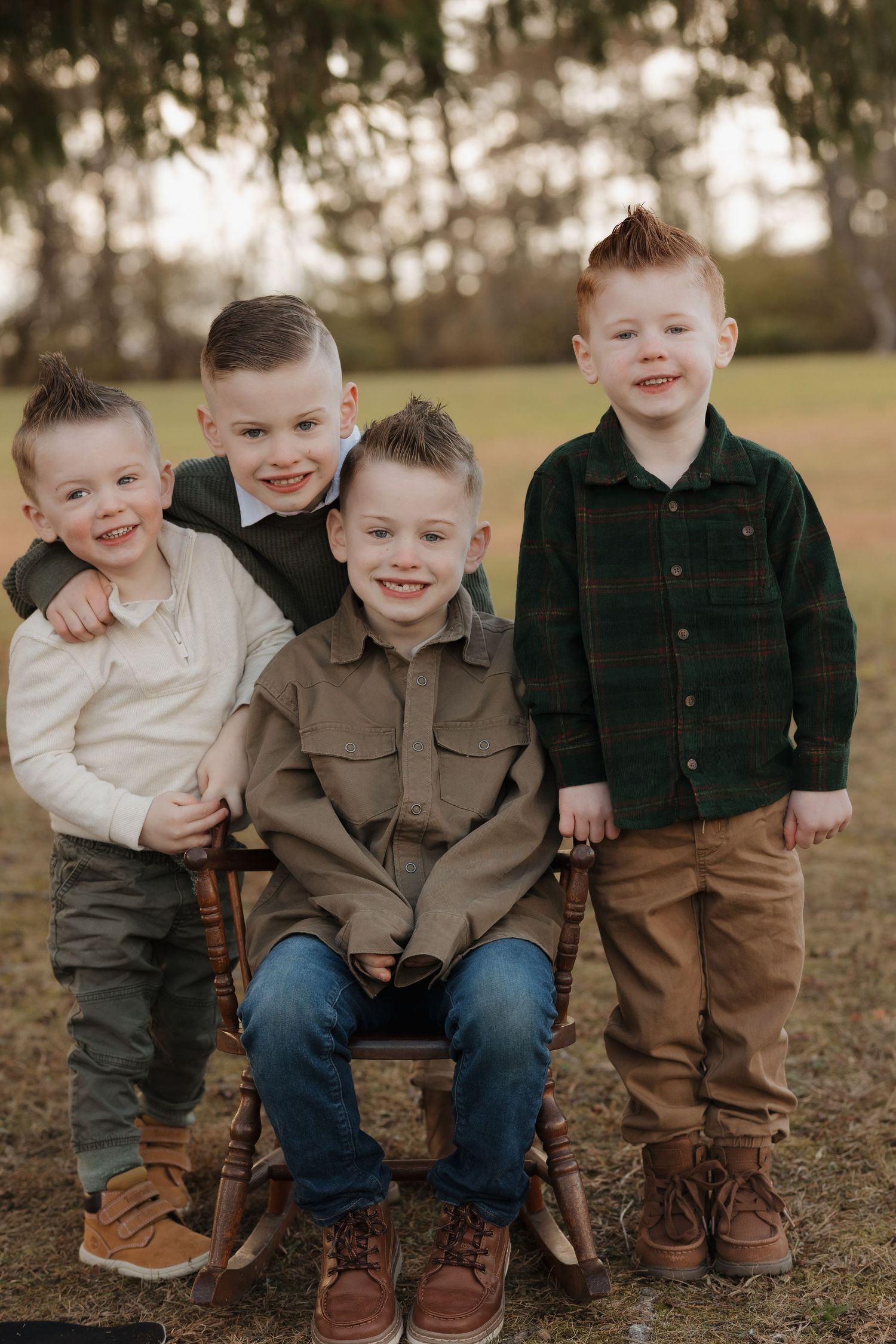 Row of children sitting together wearing coordinated brown and navy outfits.