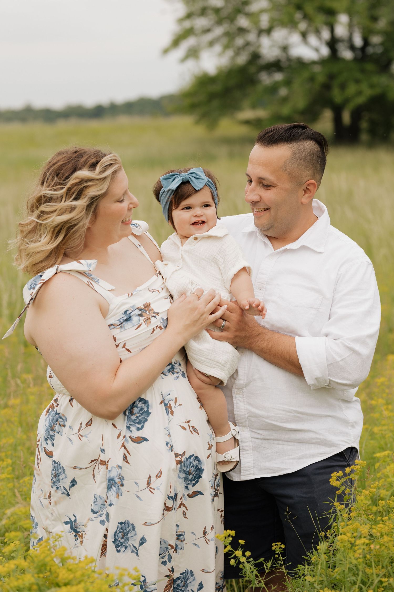 Family moment in blooming yellow wildflower field during summer photoshoot.