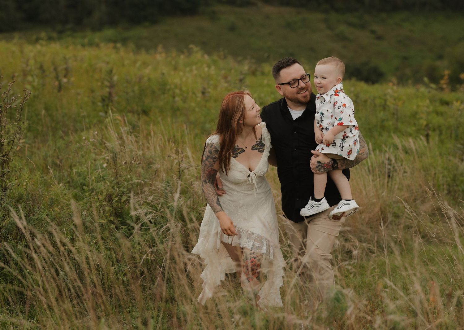 Family enjoying playful moment together in wildflower meadow during summer photoshoot.