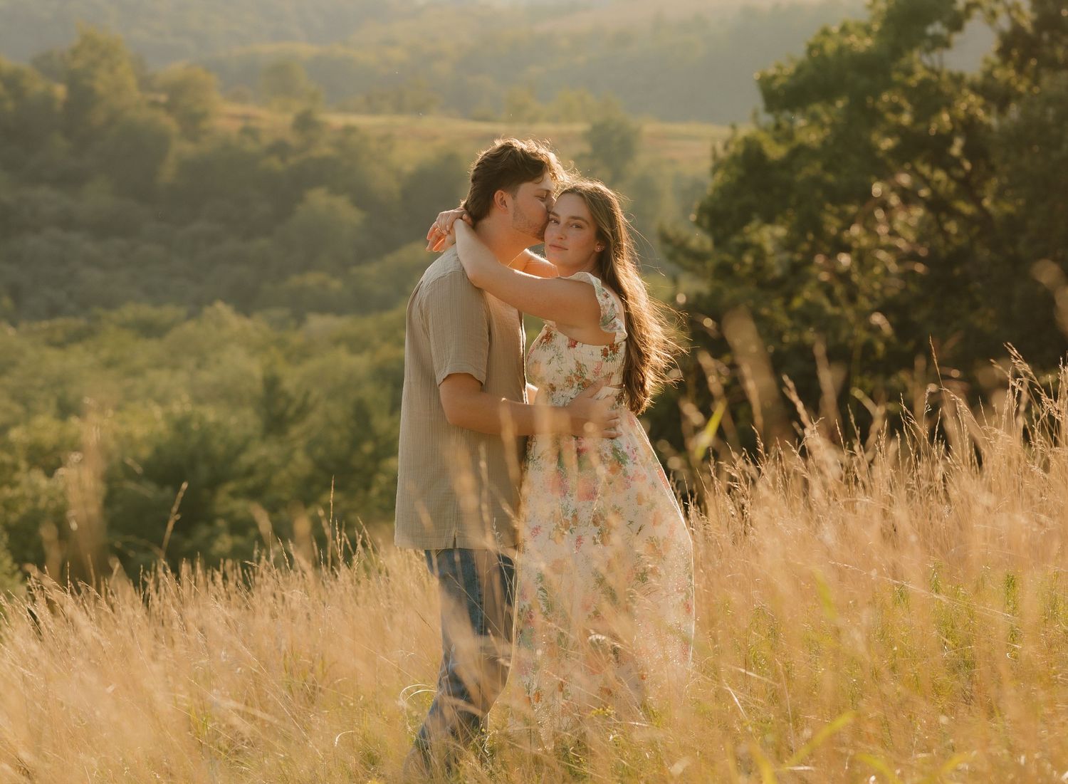 Golden sunlit meadow with tall grass and rolling hills in the background.