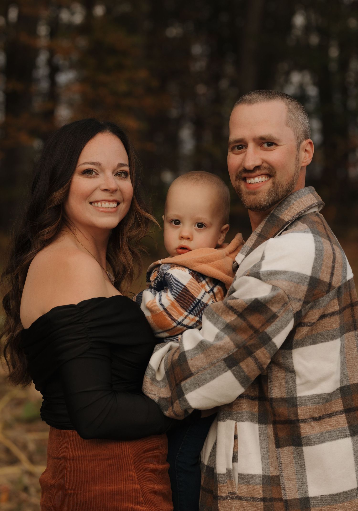 Family shares intimate moments together in warm autumn lighting.