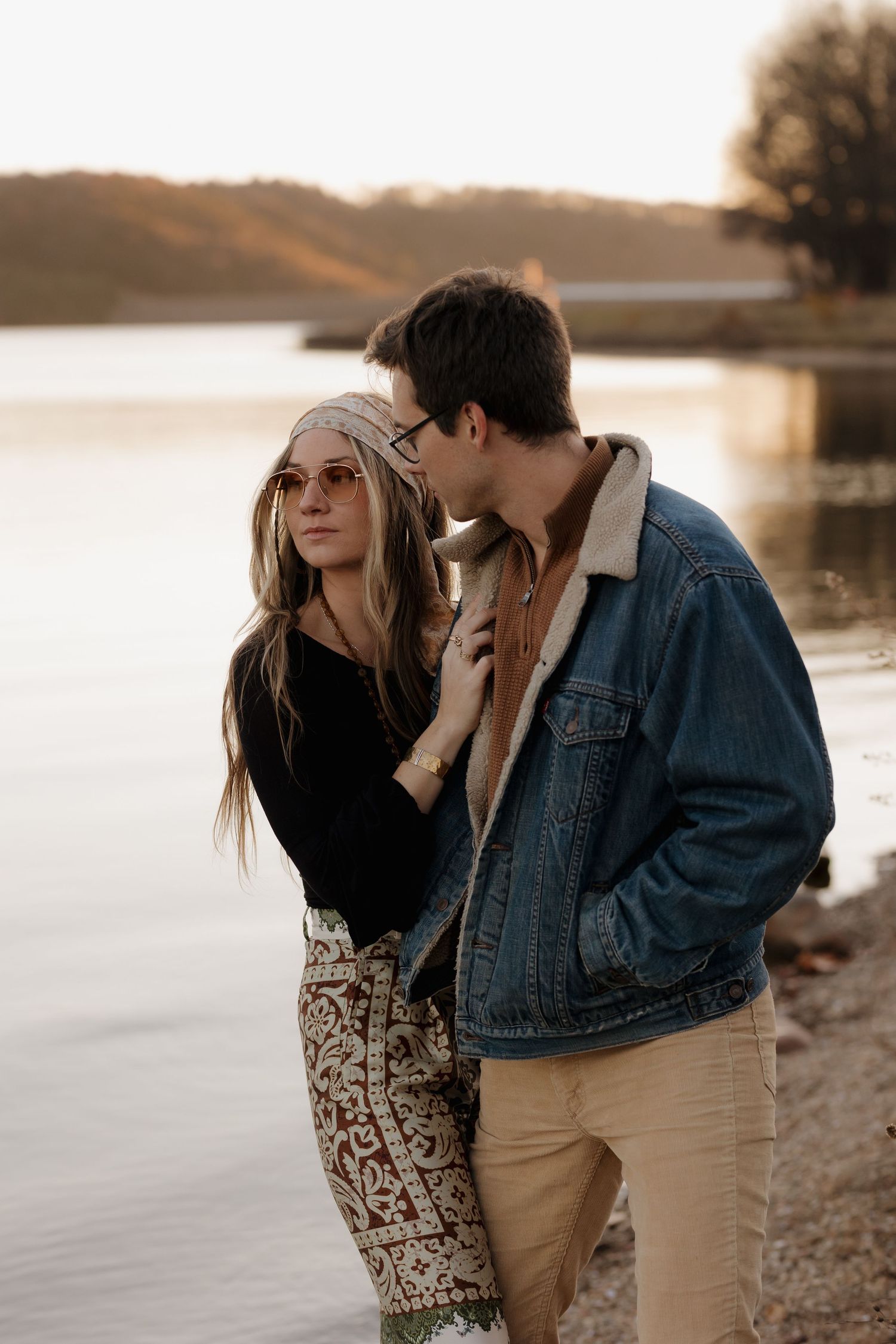 Intimate couple moment by the lake during golden hour wearing denim and floral print.