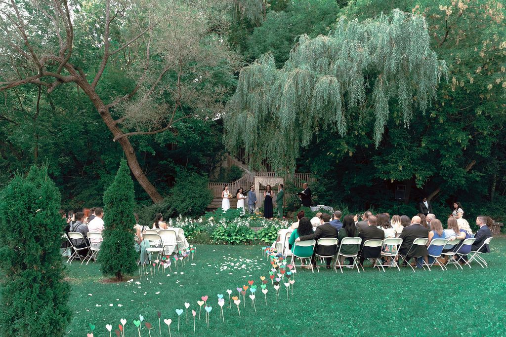 Outdoor garden ceremony surrounded by lush summer greenery at Fantasy Farm Toronto same-sex wedding