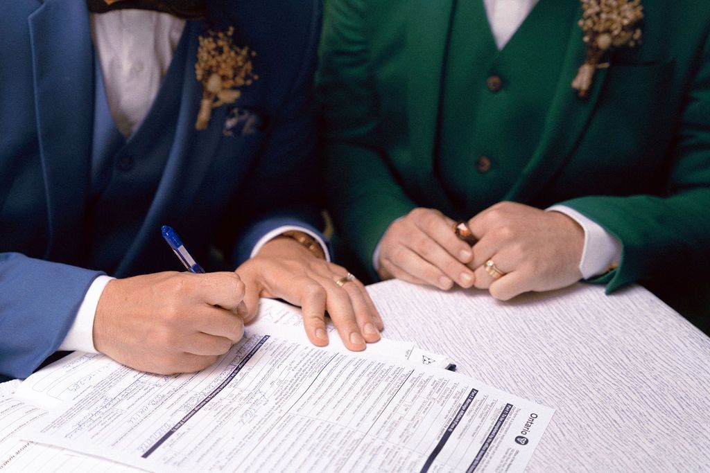 Same-Sex couple signing papers during their summer wedding at Fantasy Farm Toronto