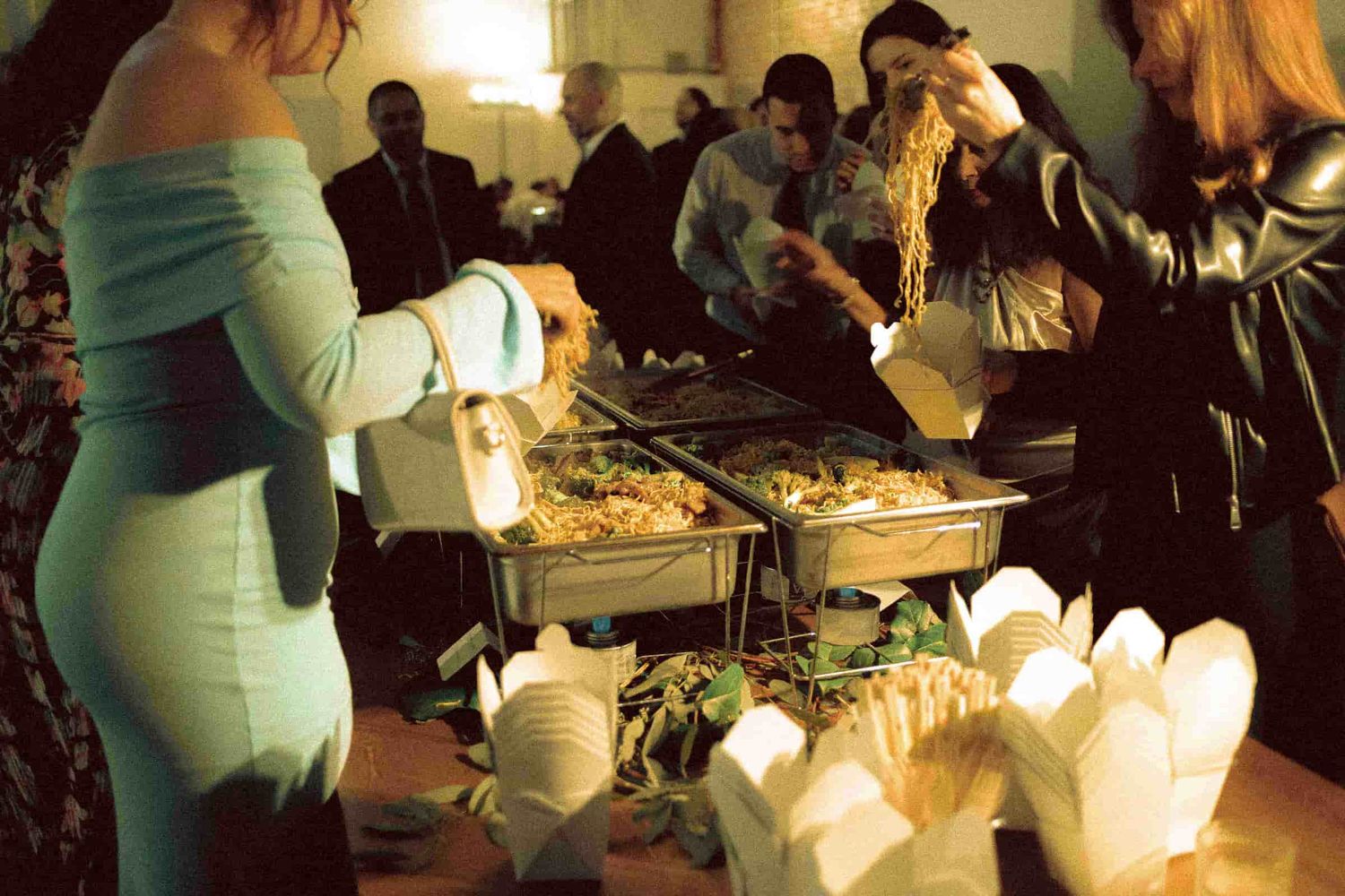 Wedding guests serving themselves food during an intimate reception.