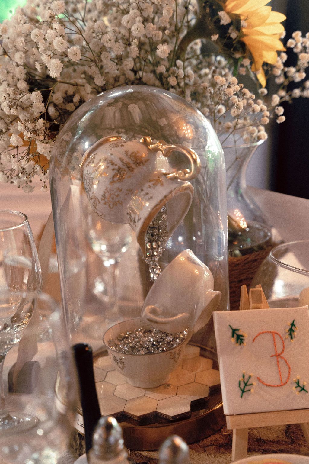 Handmade table decor and dark blue green colour palette at gay wedding reception Fantasy Farm Toronto