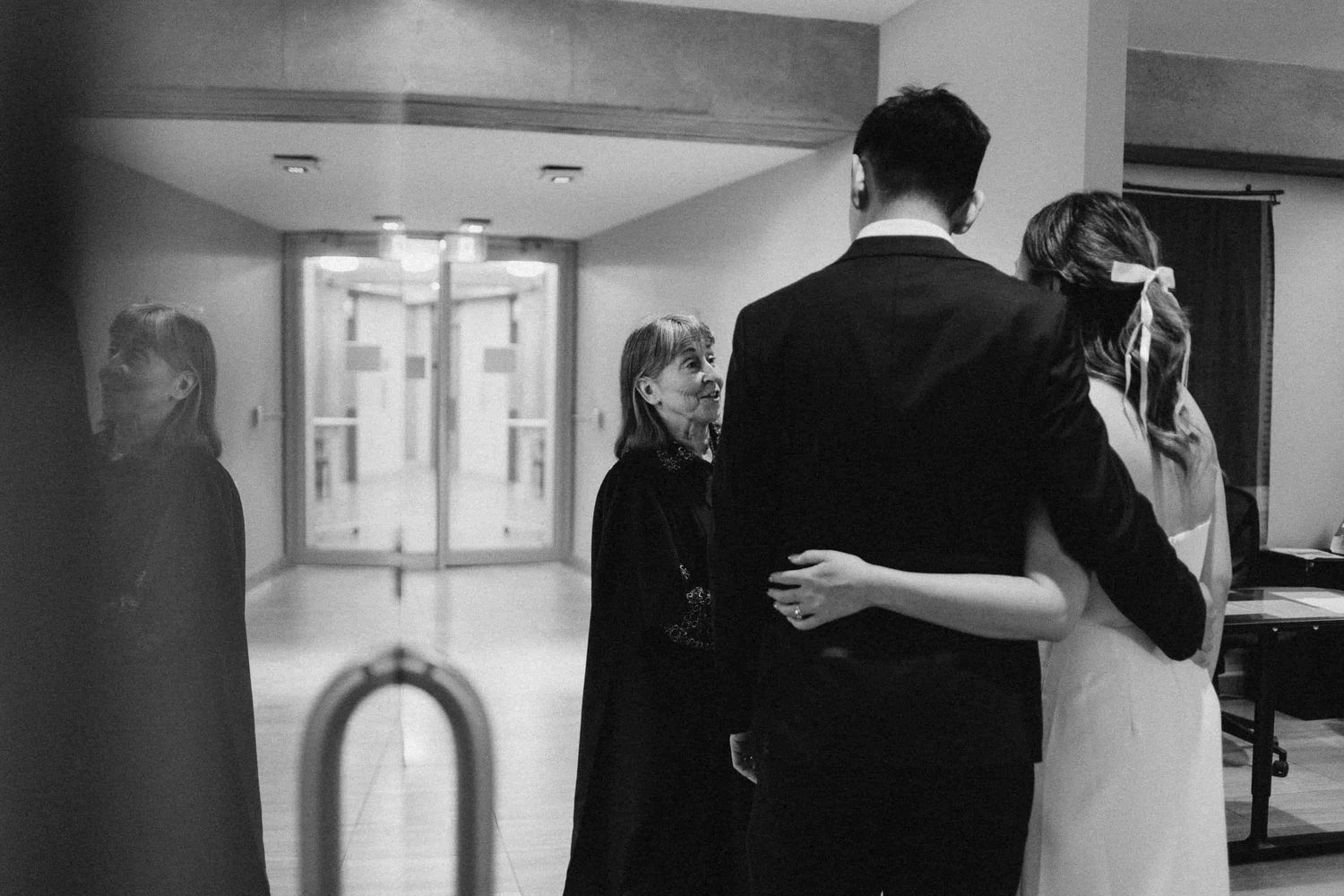 Couple hugging while listening to officiant during intimate Toronto City Hall wedding ceremony