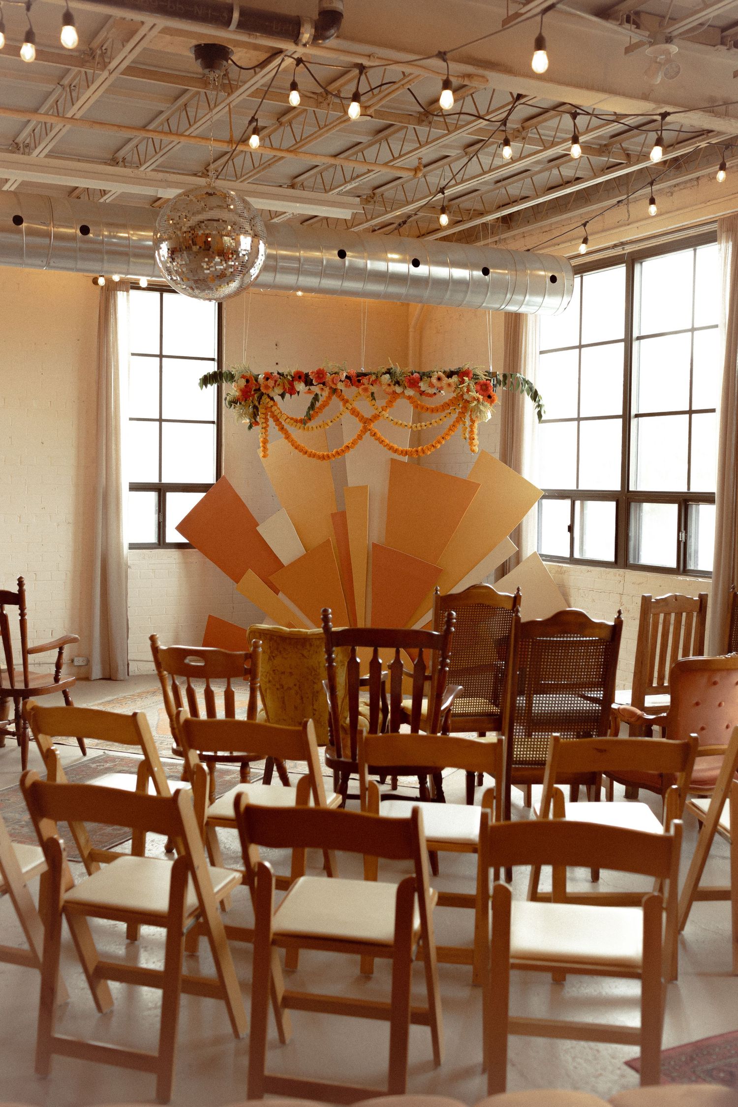 Intimate Toronto wedding ceremony design at Junto Studio featuring eclectic vintage seating and a custom-built arch