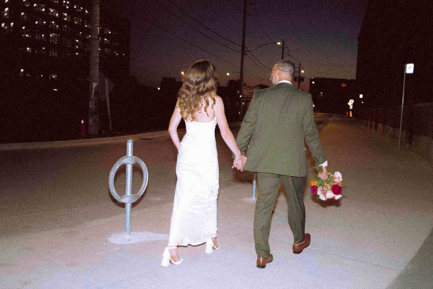 Newly married couple walking together near MOCA Toronto after their ceremony.