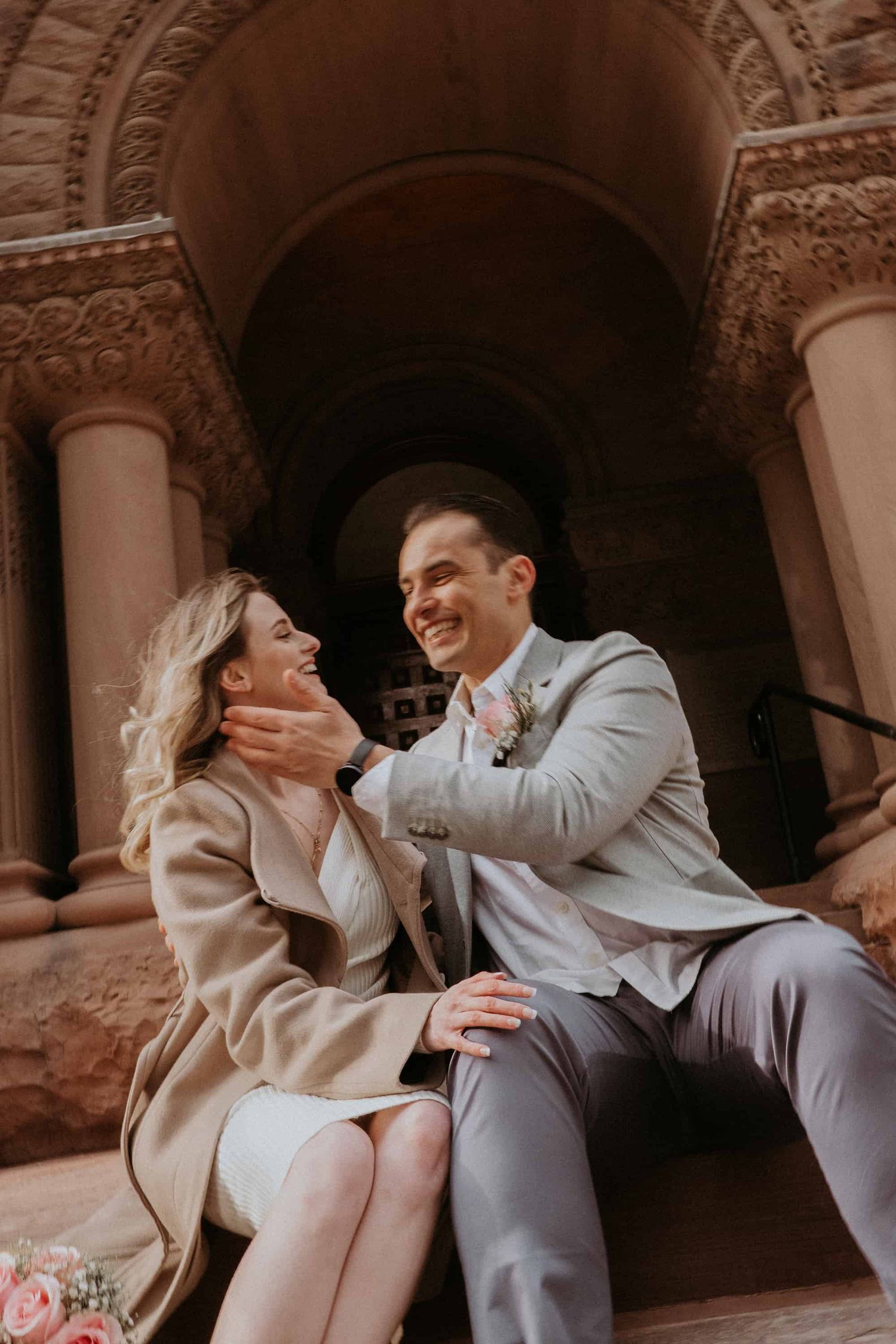 Couple smiling just before kissing in front of Old City Hall Toronto — intimate wedding photography