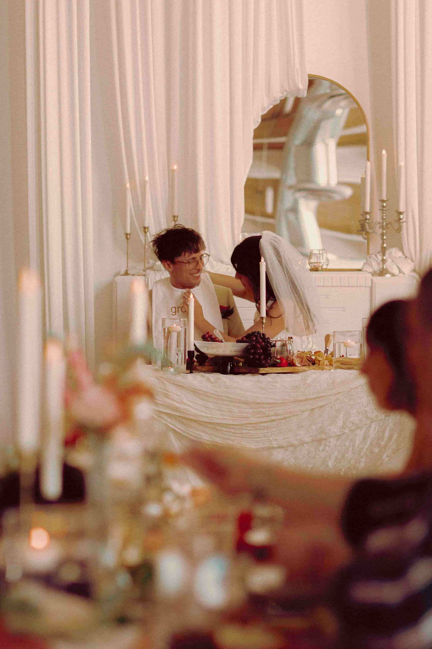 Couple wearing playful bride and groom bibs during their wedding reception.