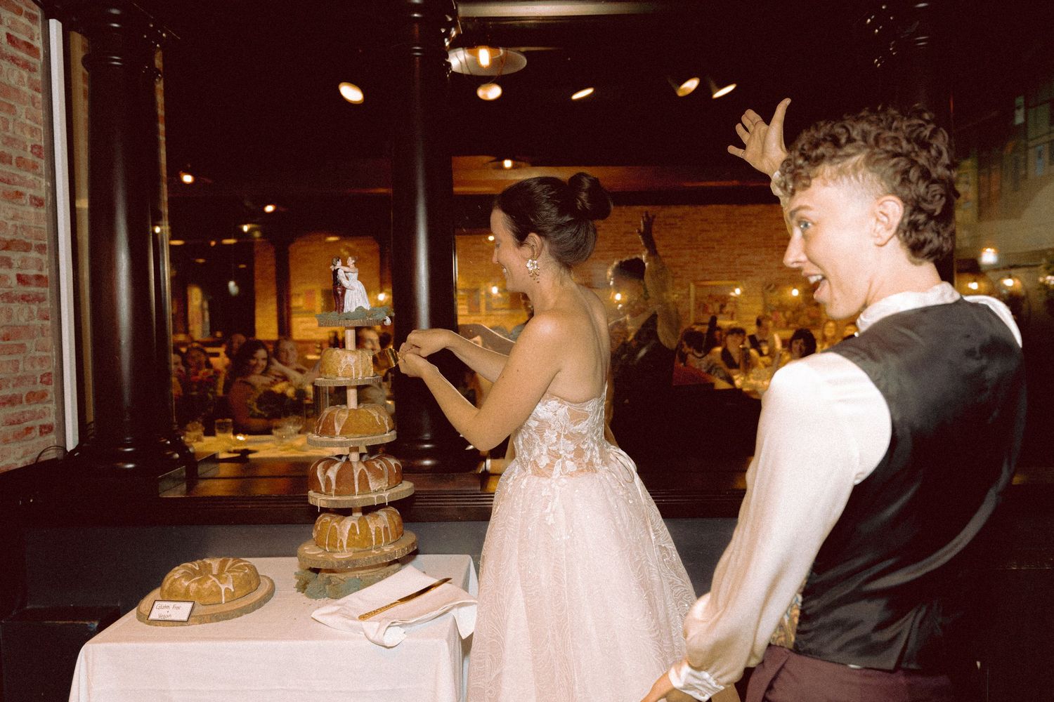 queer Couple cutting homemade lemon poppyseed bundt cake at Granite Brewery Toronto wedding
