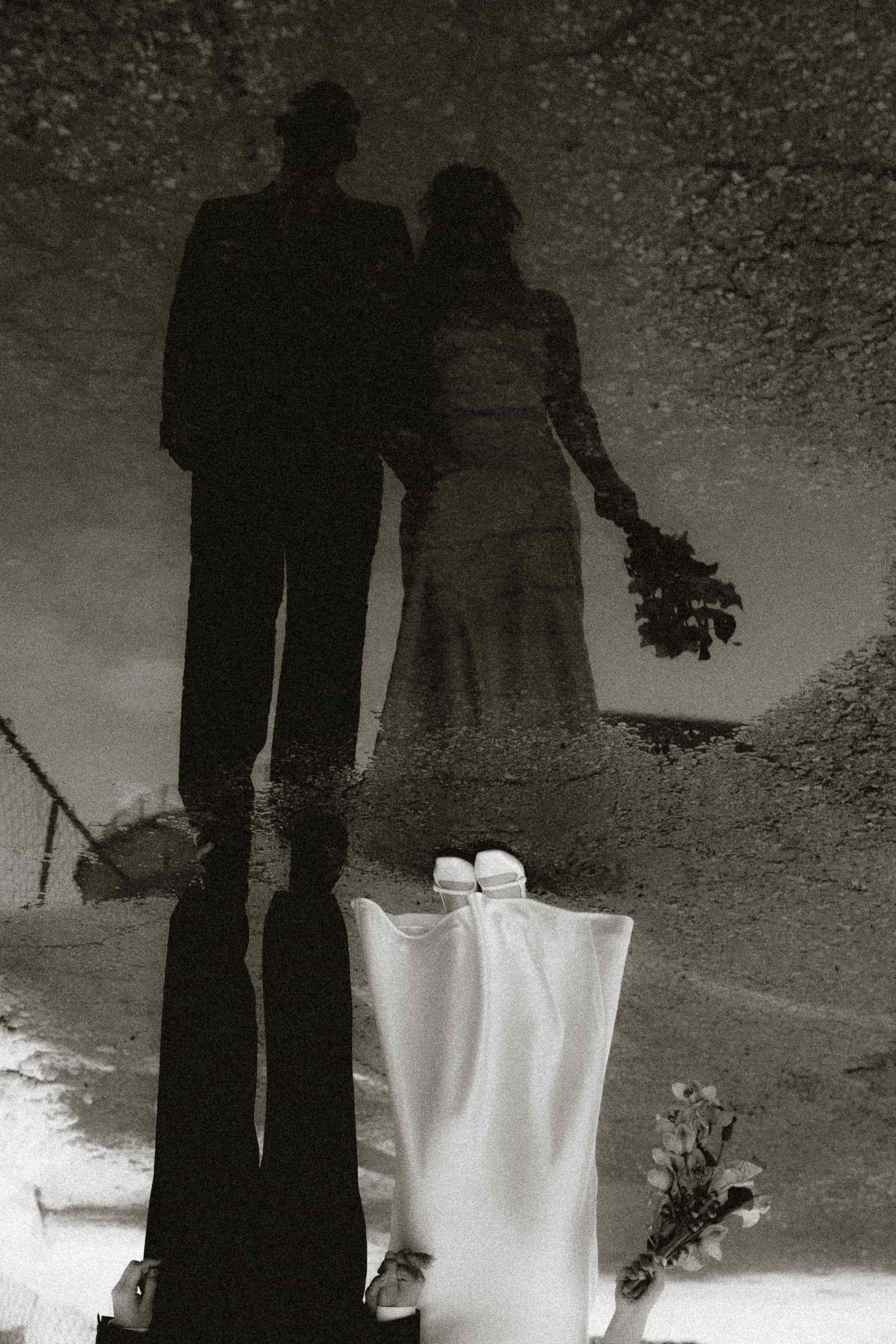 Moody portrait of a newly married couple reflected in a puddle near Toronto Micro Weddings venue
