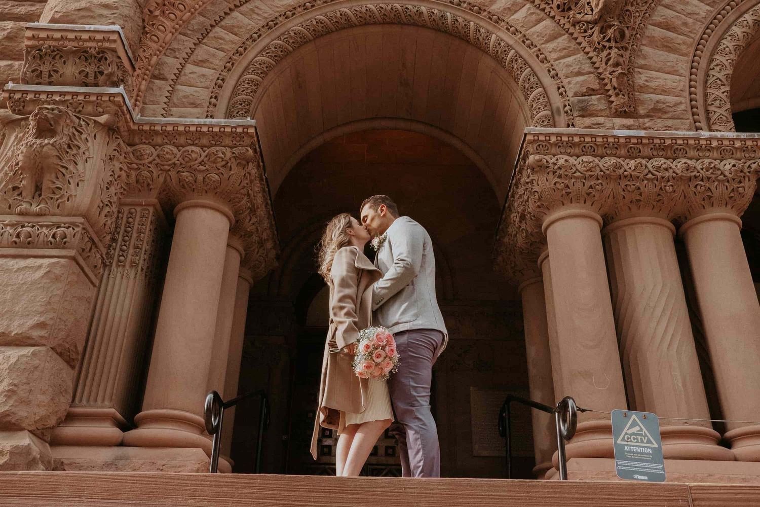 Couple kissing full body portrait in front of Old City Hall Toronto wedding photography