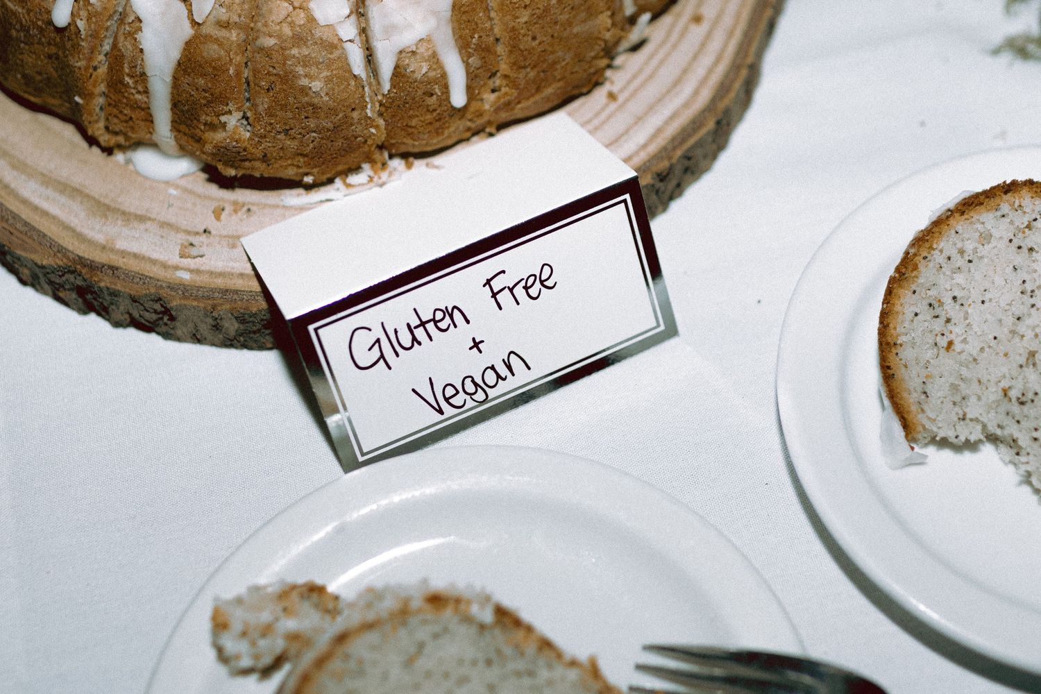 queer Couple cutting homemade lemon poppyseed bundt cake at Granite Brewery Toronto wedding