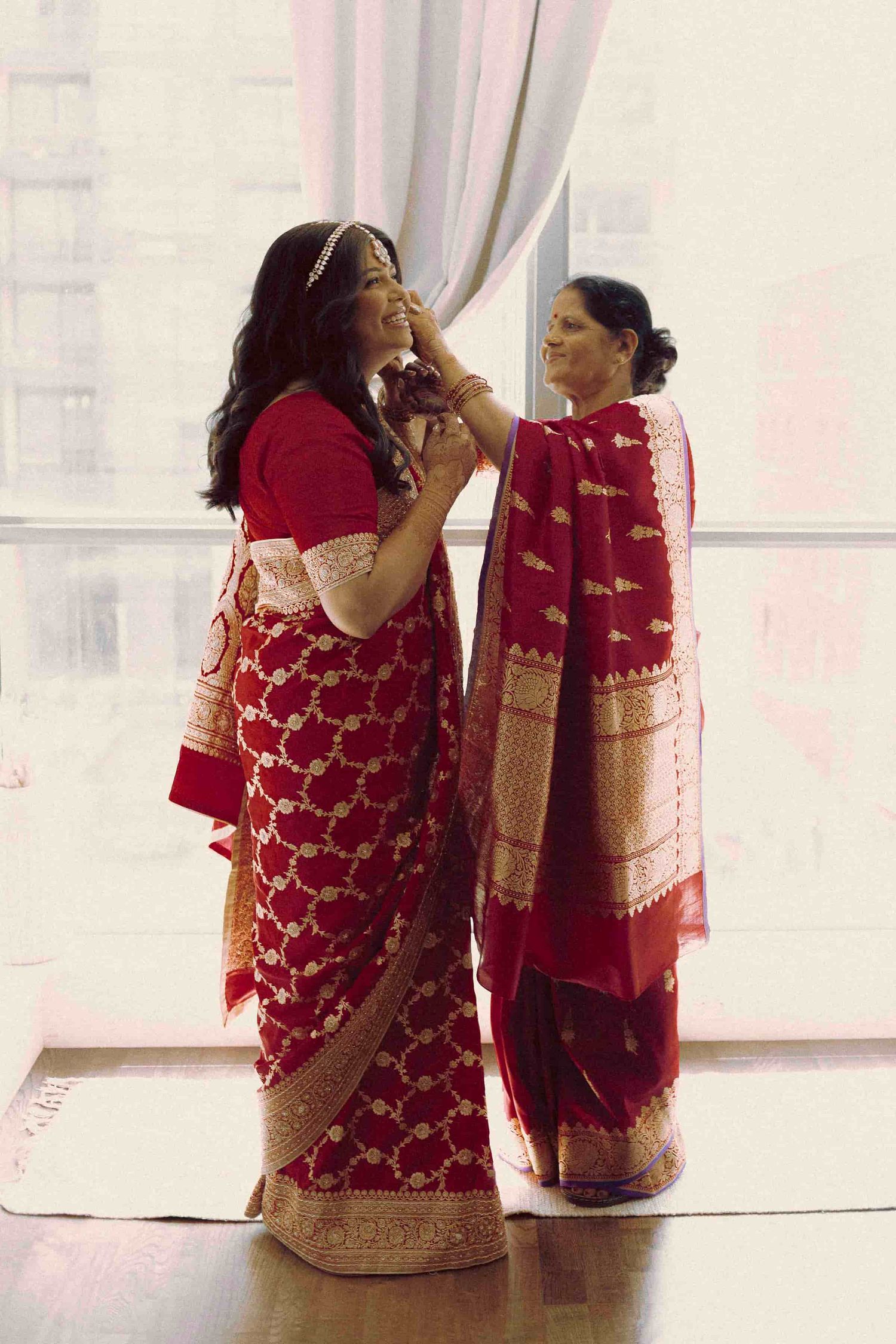 Family members assisting with traditional wedding preparations before the ceremony.