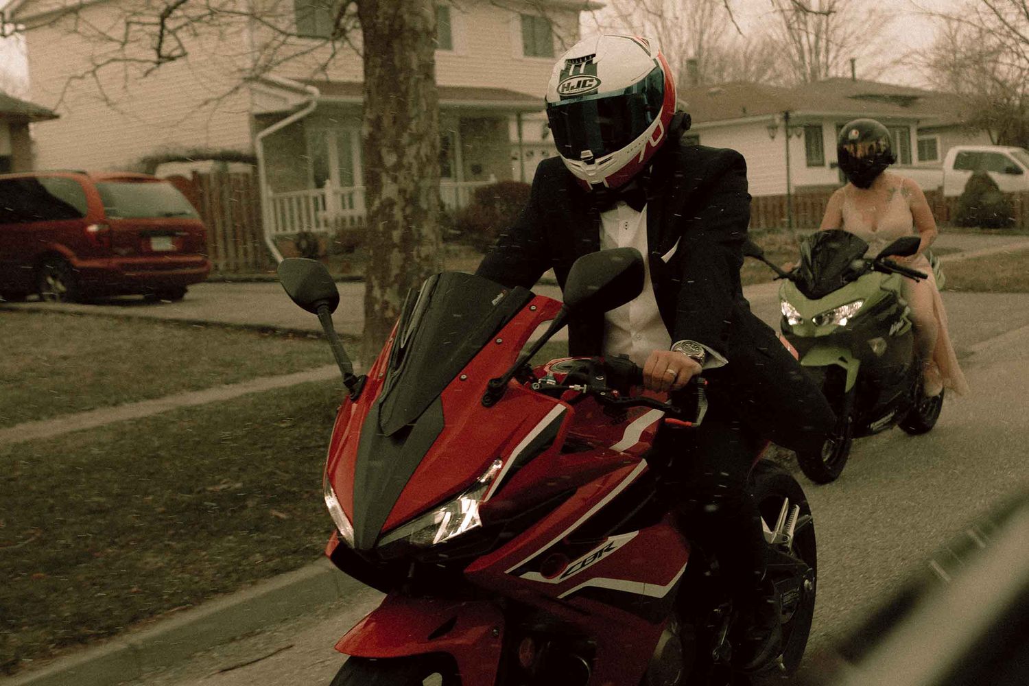 Untraditional wedding - queer couple riding motorcycle during a snowfall in Ontario during their wedding day