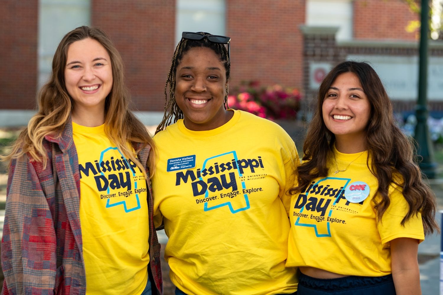 Group wearing bright yellow t-shirts smile together in casual business and campus settings.