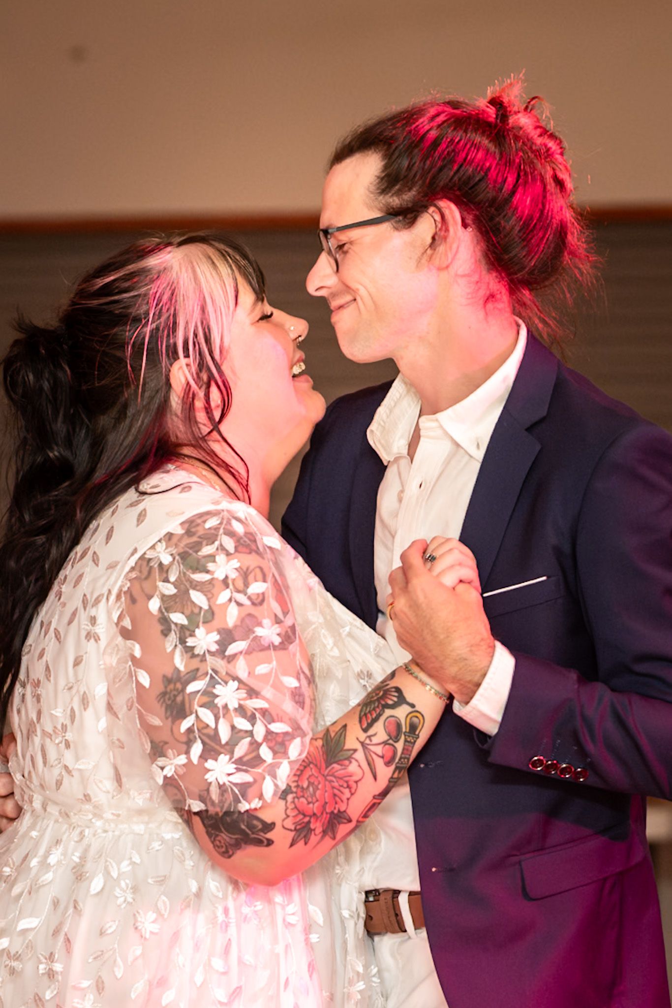 A romantic series of shots showing a tender wedding dance moment illuminated in soft pink lighting.