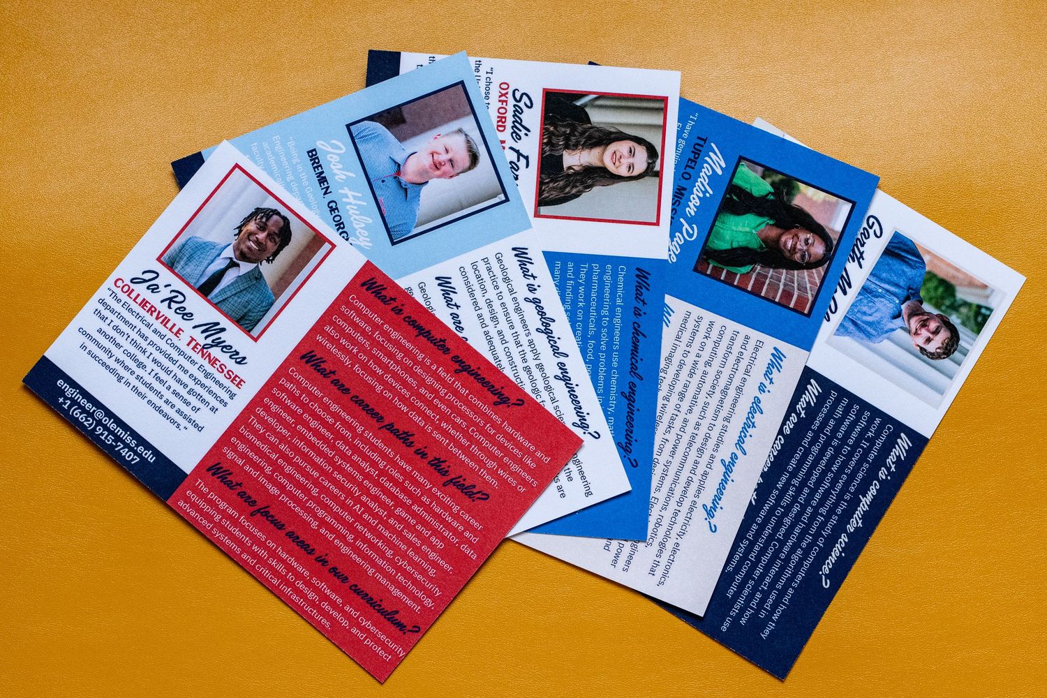 Fan of red and blue political campaign flyers with candidate photos spread on an orange background.