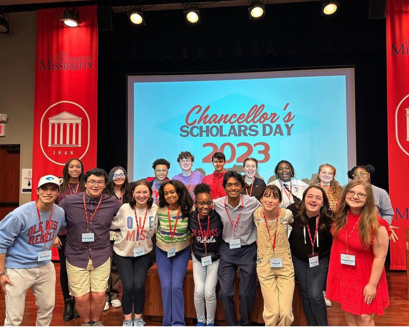 Students pose together at Chancellor's Scholars Day 2023 event in a university auditorium.