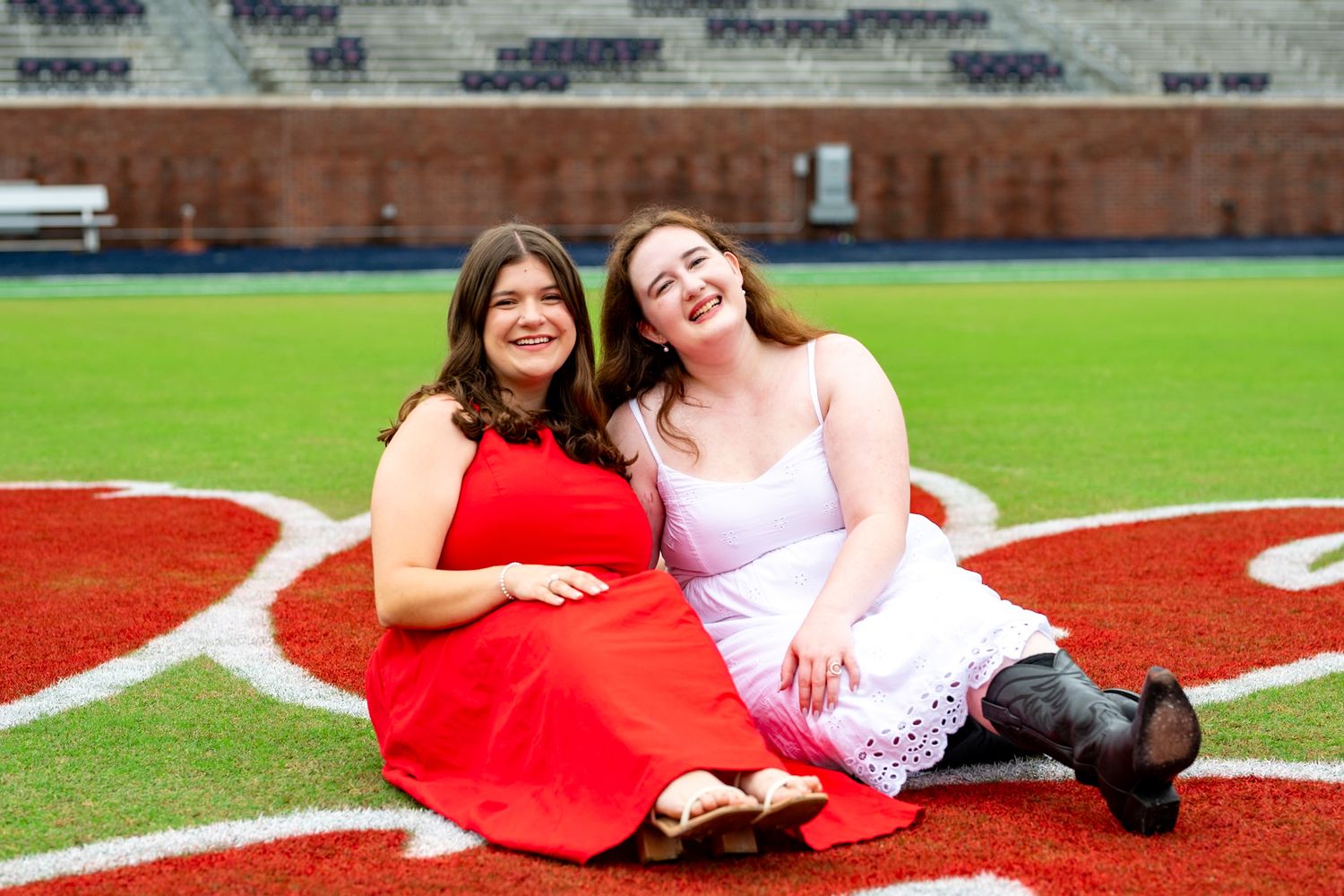 A person in white lounges on a red running track for a photo shoot.