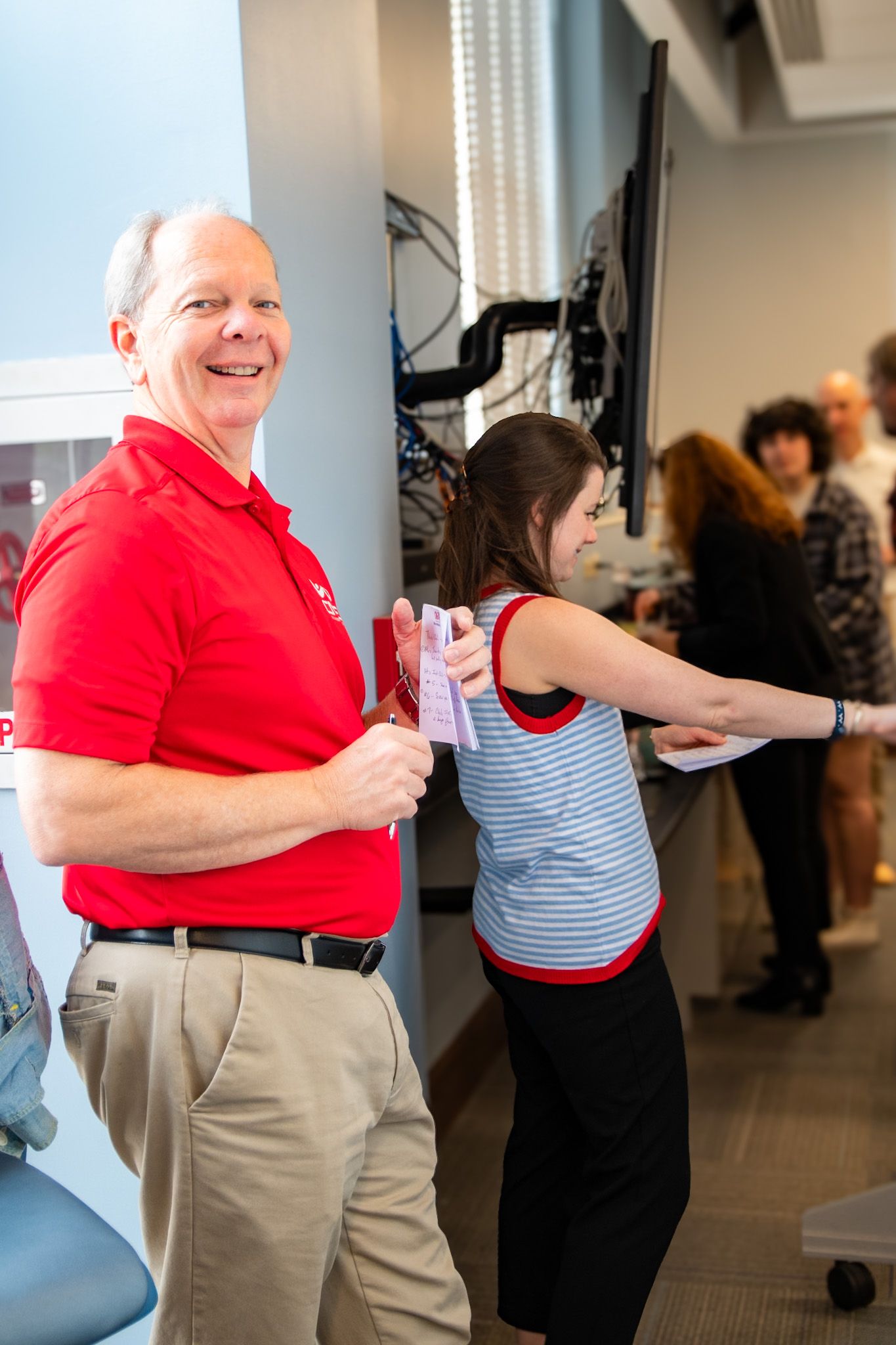 Group participates in an energetic team-building exercise in an office space.