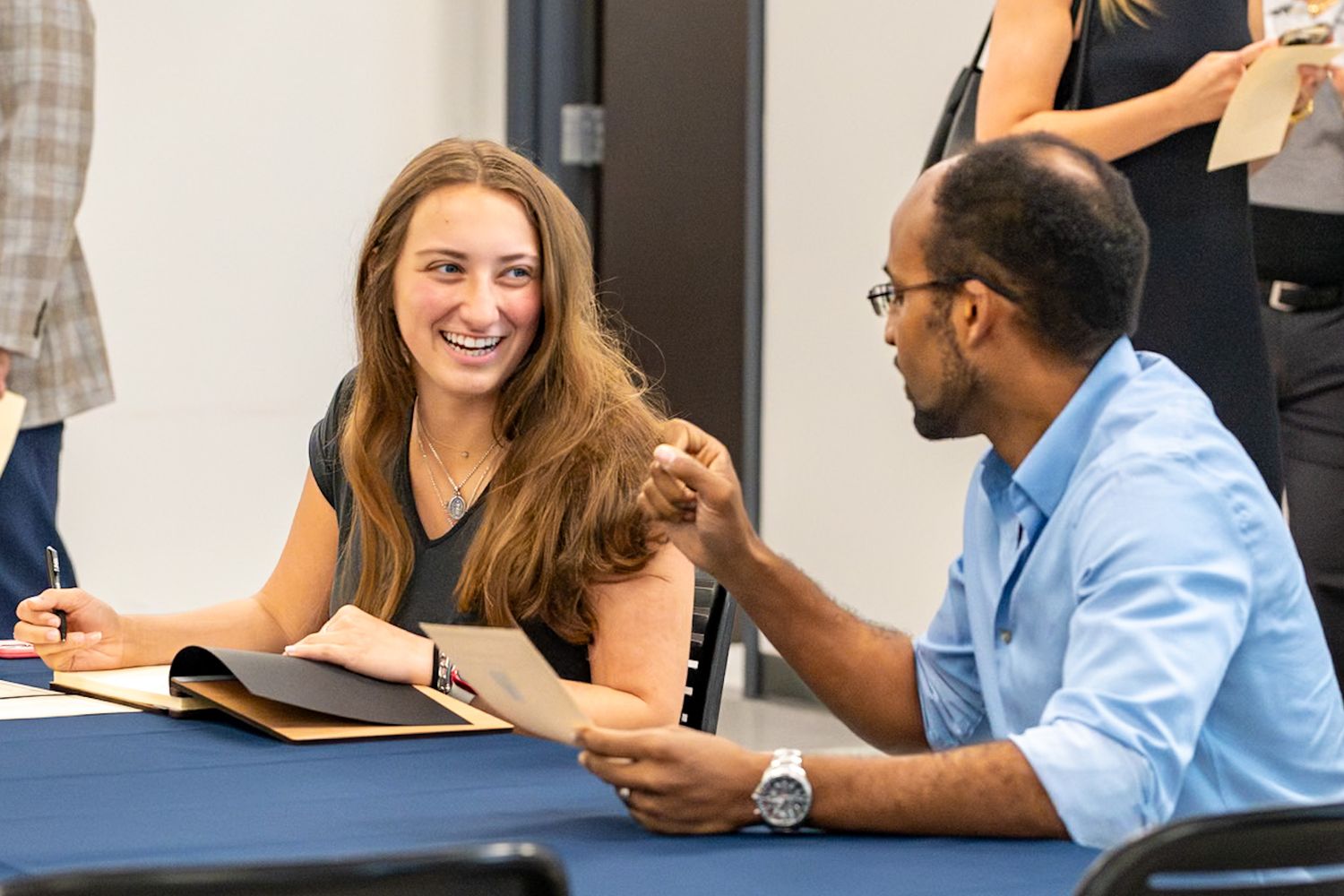 College students collaborate during a study session at a table while reviewing materials and sharing ideas together.