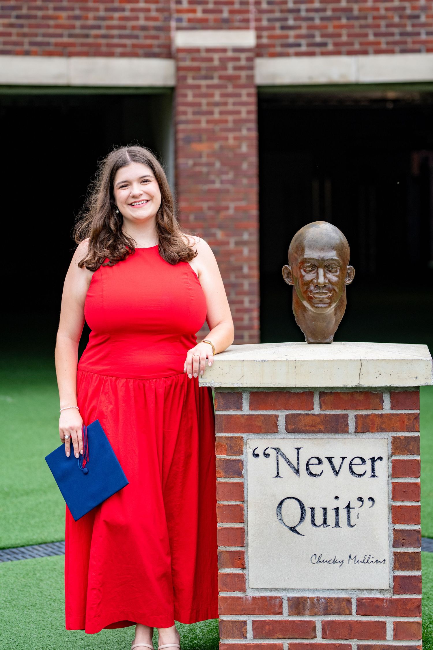 A person in a bright red dress poses next to inspirational 