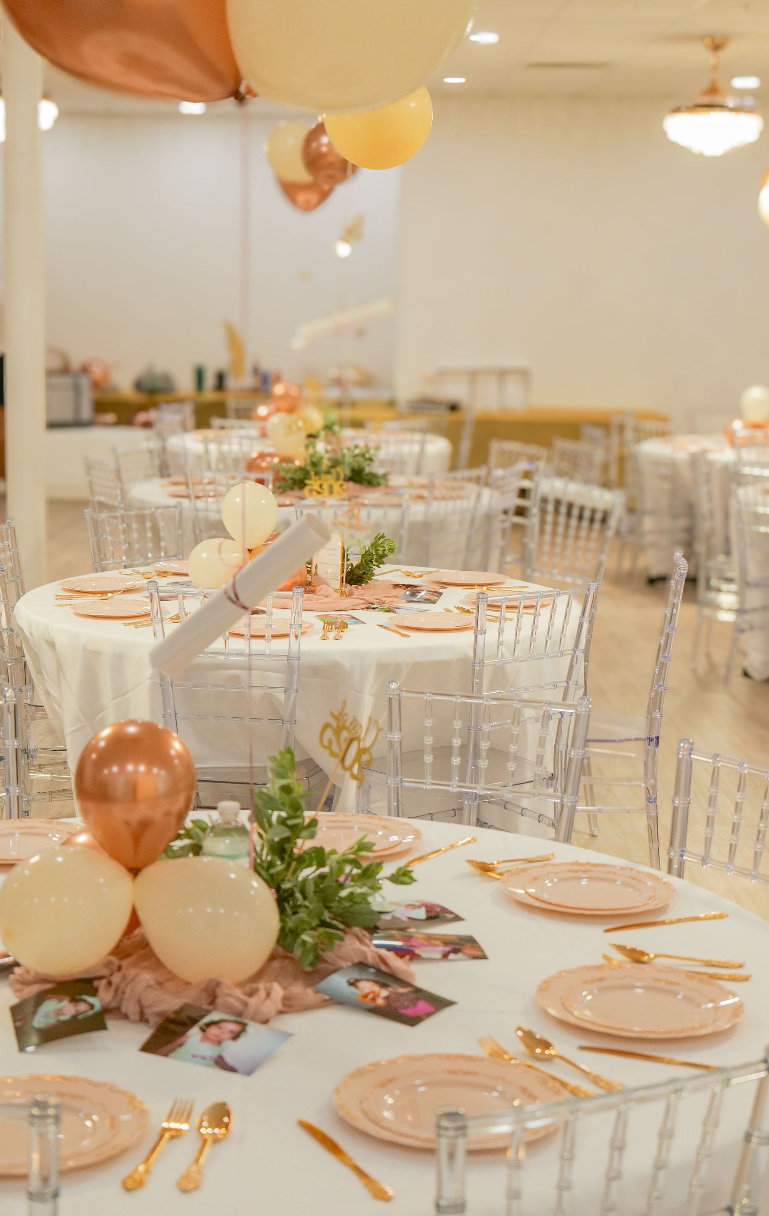 An elegant party setup with clear chairs, pink place settings, and floating balloons. Photo shot by Mikiah Nicole Dixon
