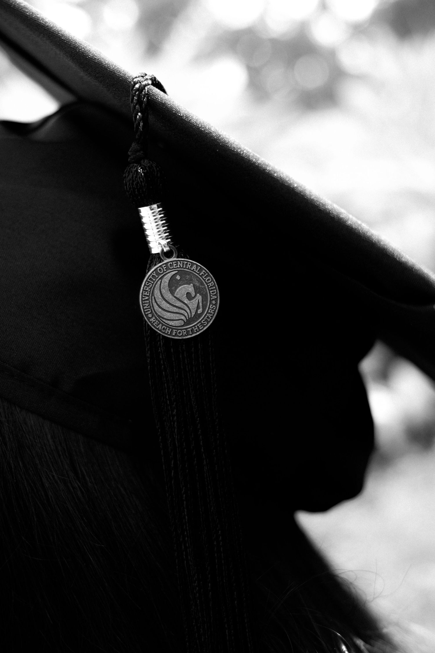 Close-up black and white images focusing on an ornate circular pendant or medallion. Photo shot by Mikiah Nicole Dixon