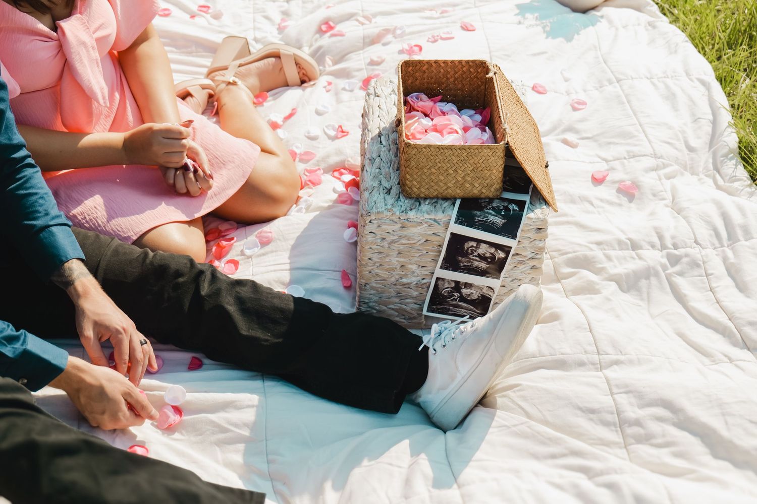 A peaceful outdoor gathering with ultrasound photos and a decorative box laid out on a white blanket. Photo shot by Mikiah Nicole Dixon