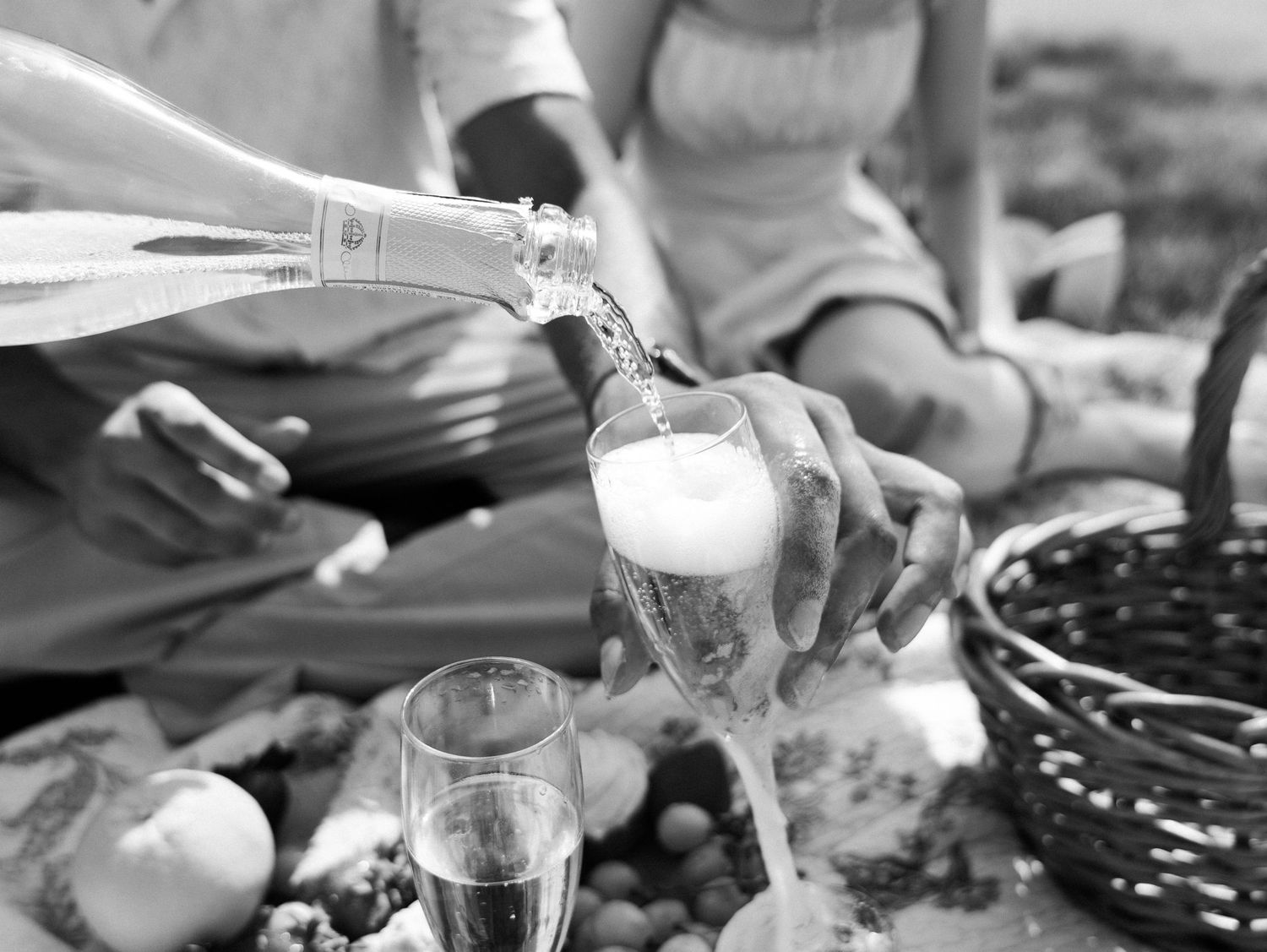 Close-up shot of hands pouring drinks at an outdoor picnic gathering. Photo shot by Mikiah Nicole Dixon