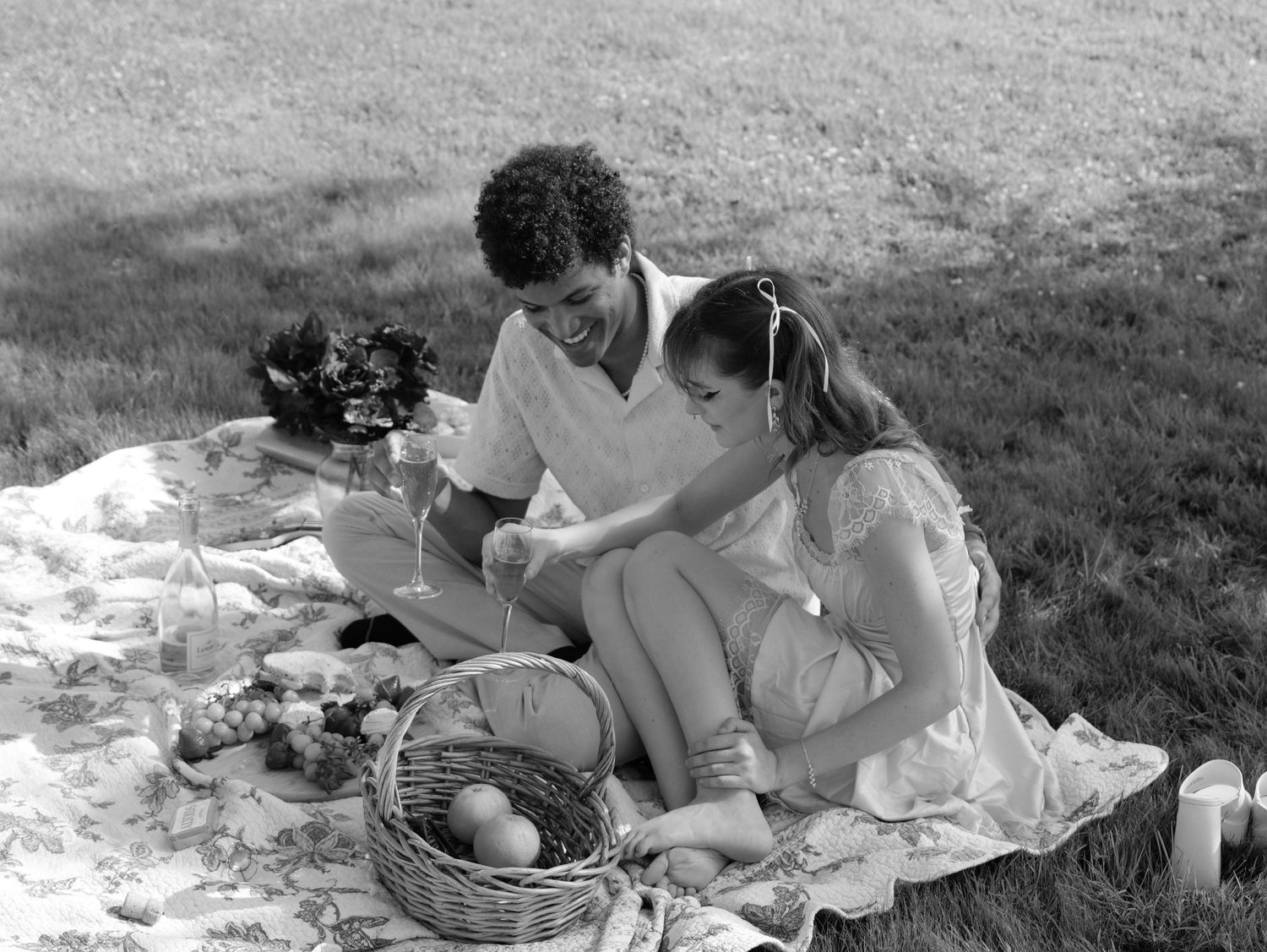 A vintage black and white collage shows several scenes of people enjoying an outdoor picnic on a blanket. Photo shot by Mikiah Nicole Dixon