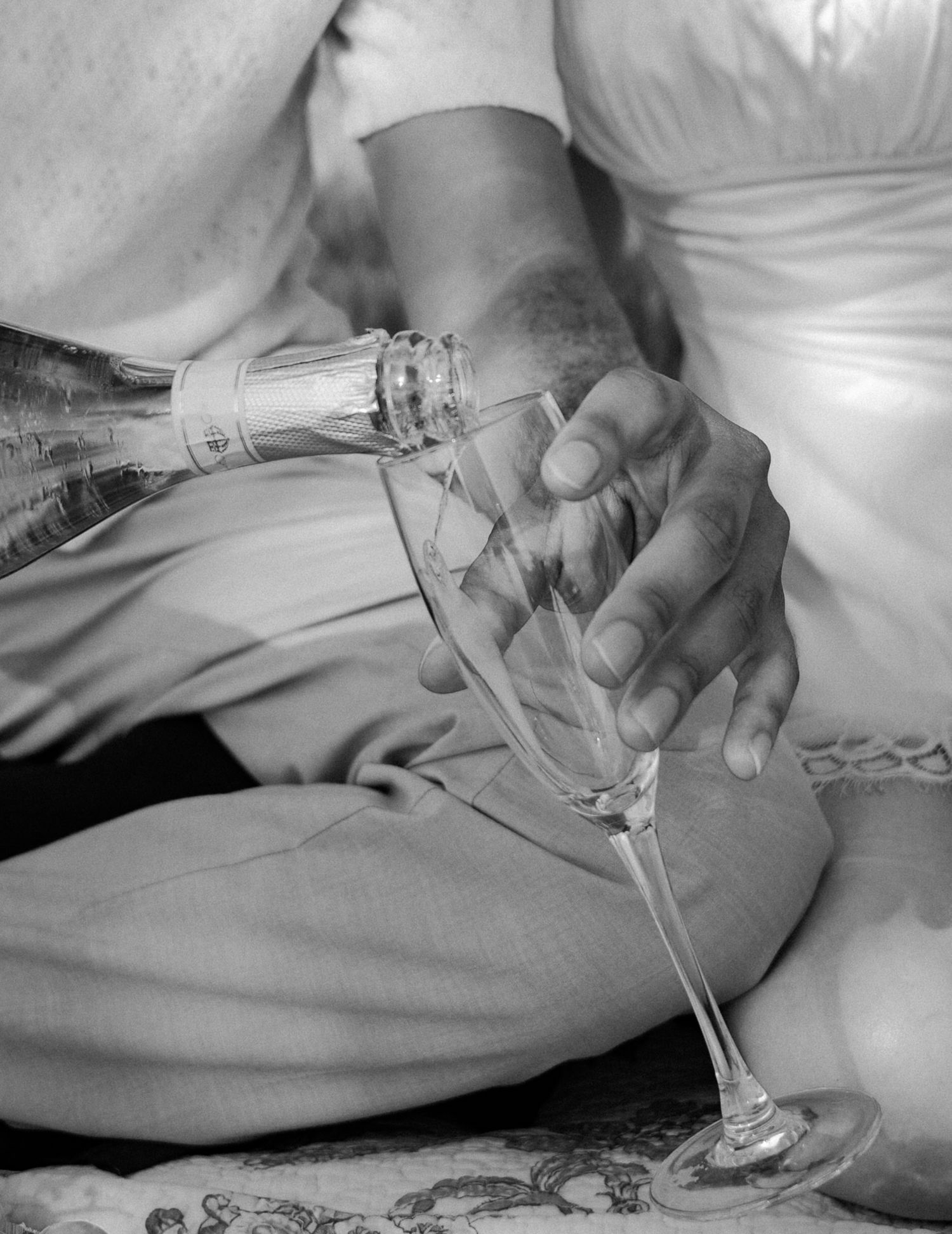 Black and white close-up of hands holding wine glasses during an outdoor gathering. Photo shot by Mikiah Nicole Dixon