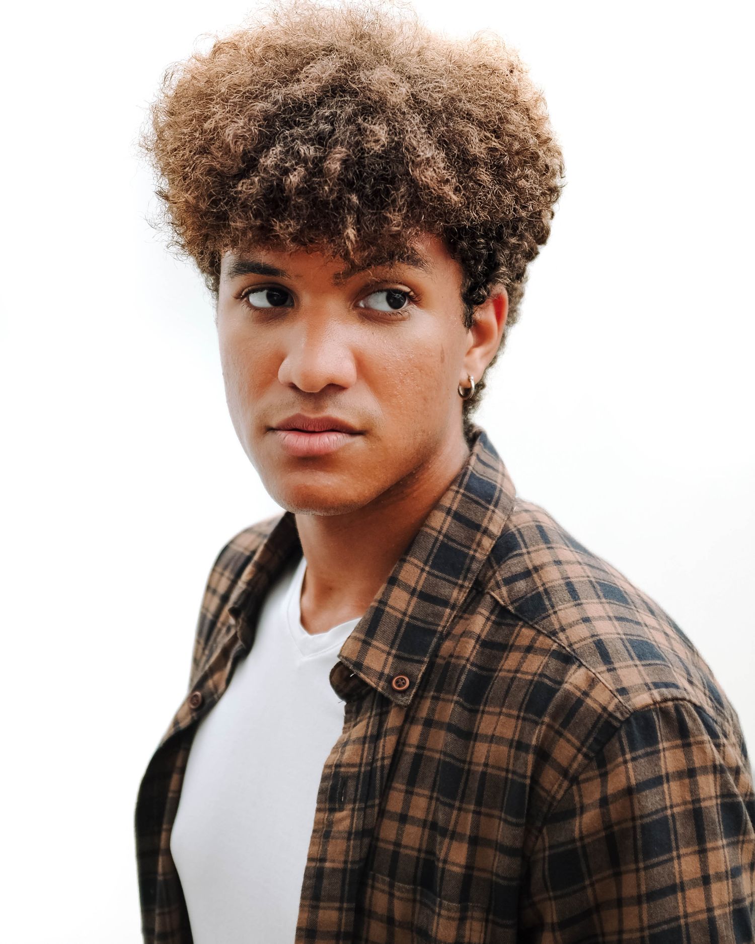 Fashion portrait with brown plaid shirt and white tee with natural curly hairstyle. Photo shot by Mikiah Nicole Dixon